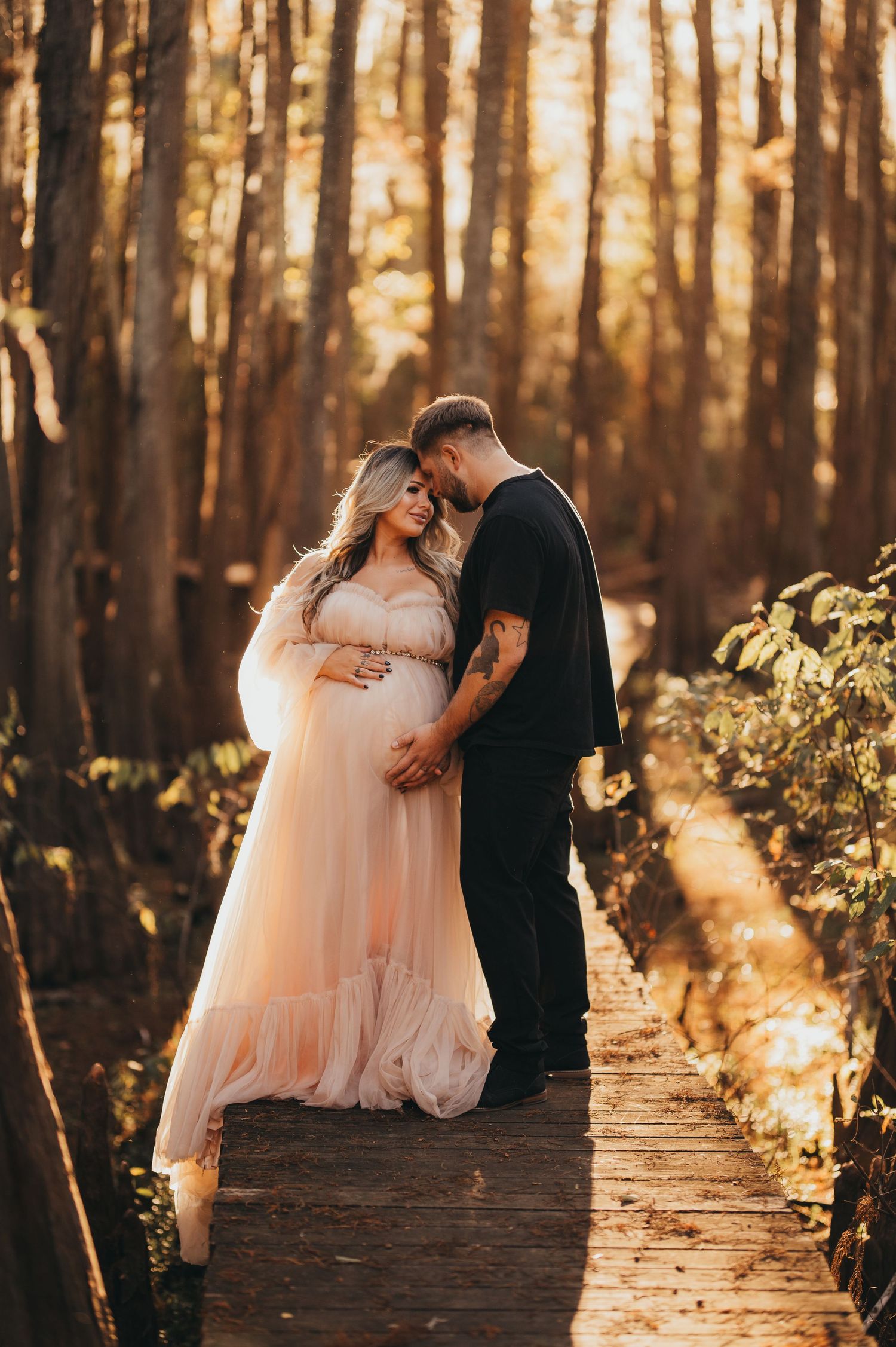 Couple celebrating their growing family during a beautiful outdoor maternity photography session in East Texas