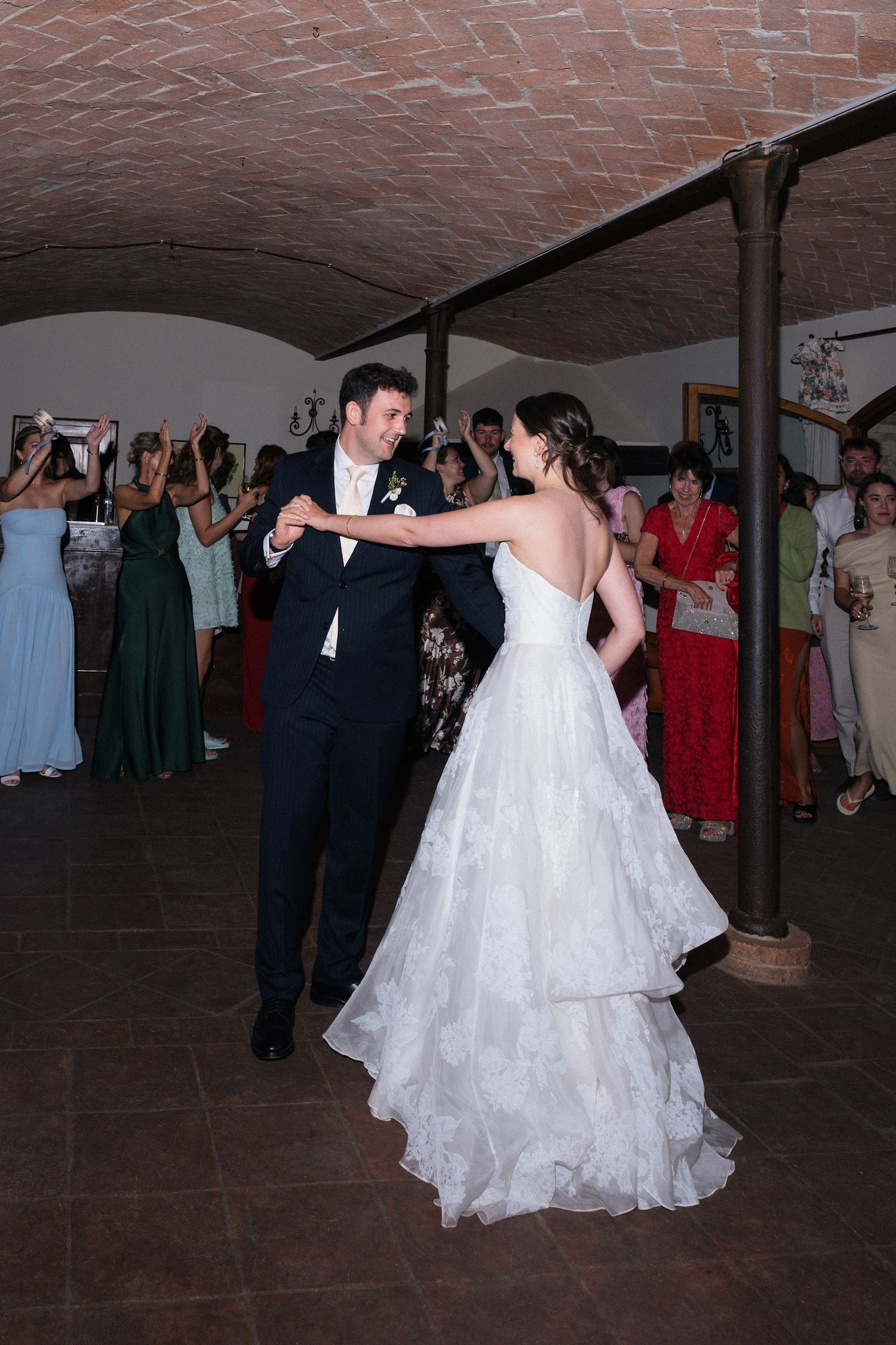 Bride and groom share their first dance in a rustic vaulted venue.