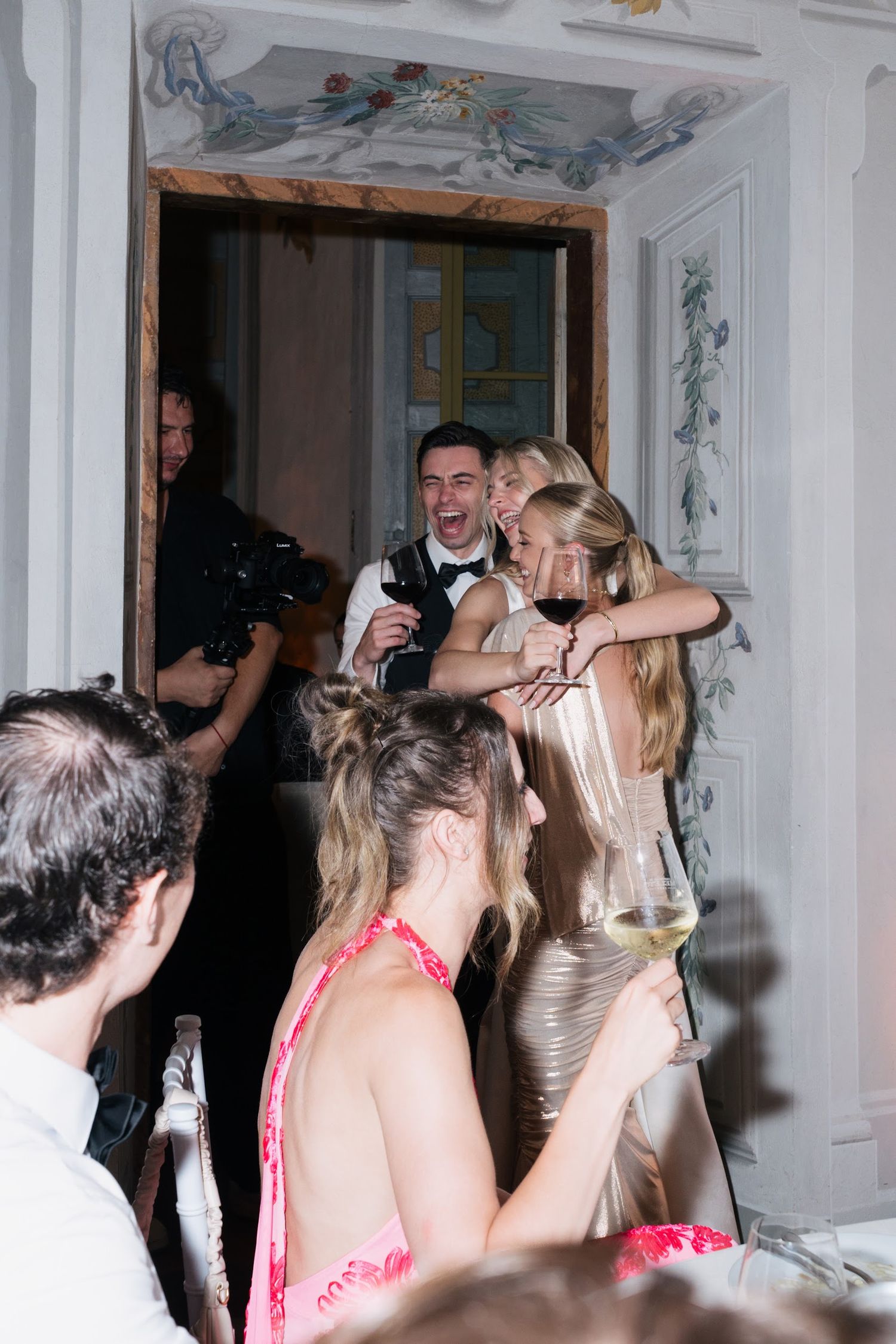 Bride and guests laughing joyfully during lively Italian castle wedding reception celebration.