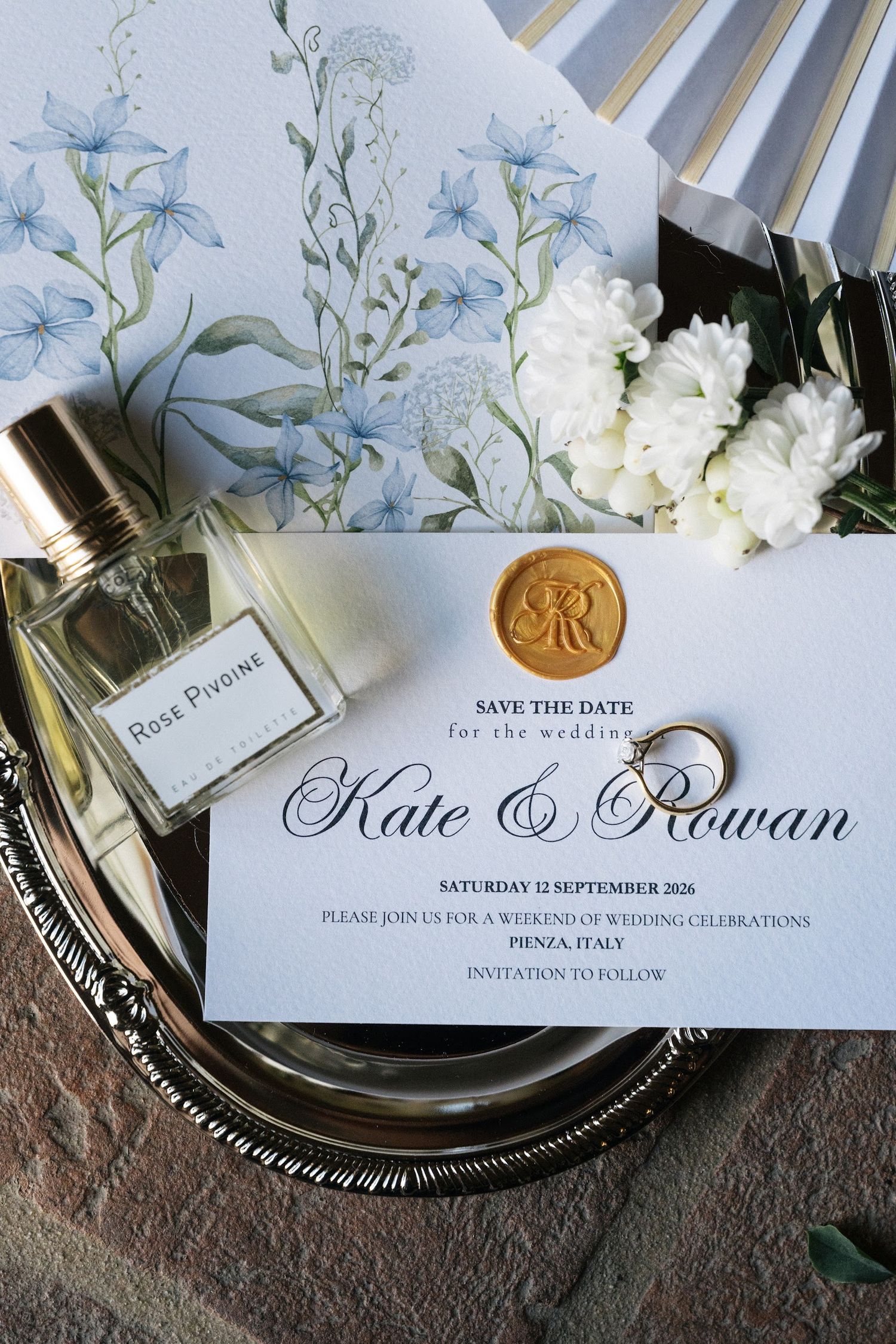 Elegant wedding save the date card for Kate and Rowan in Pienza Italy with gold wax seal perfume and floral fan.