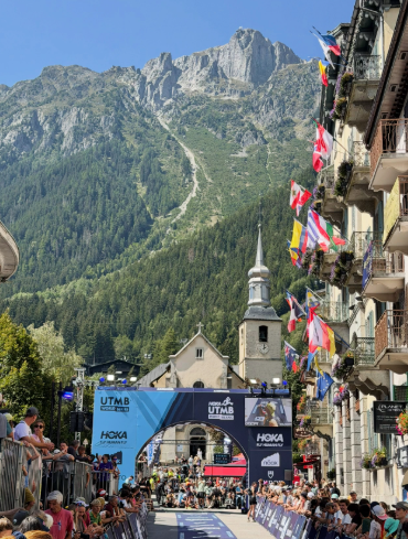 UTMB ultra marathon finish line in Chamonix with alpine church and mountain scenery behind.