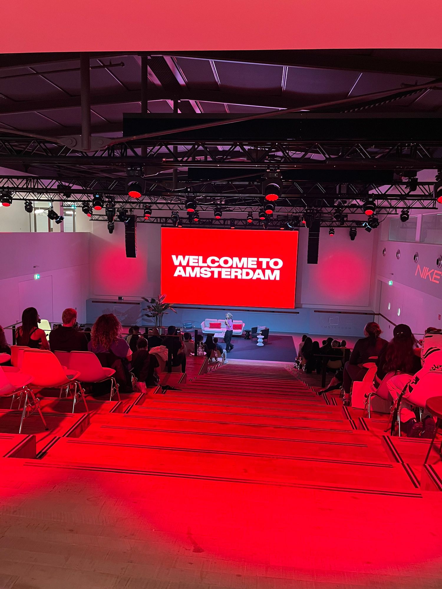 Welcome to Amsterdam displayed on red LED screen at a conference venue in Amsterdam.
