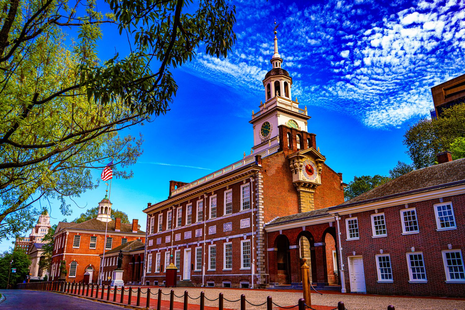 Independence Hall in Philadelphia under a vivid blue sky with wispy clouds on a bright sunny day.