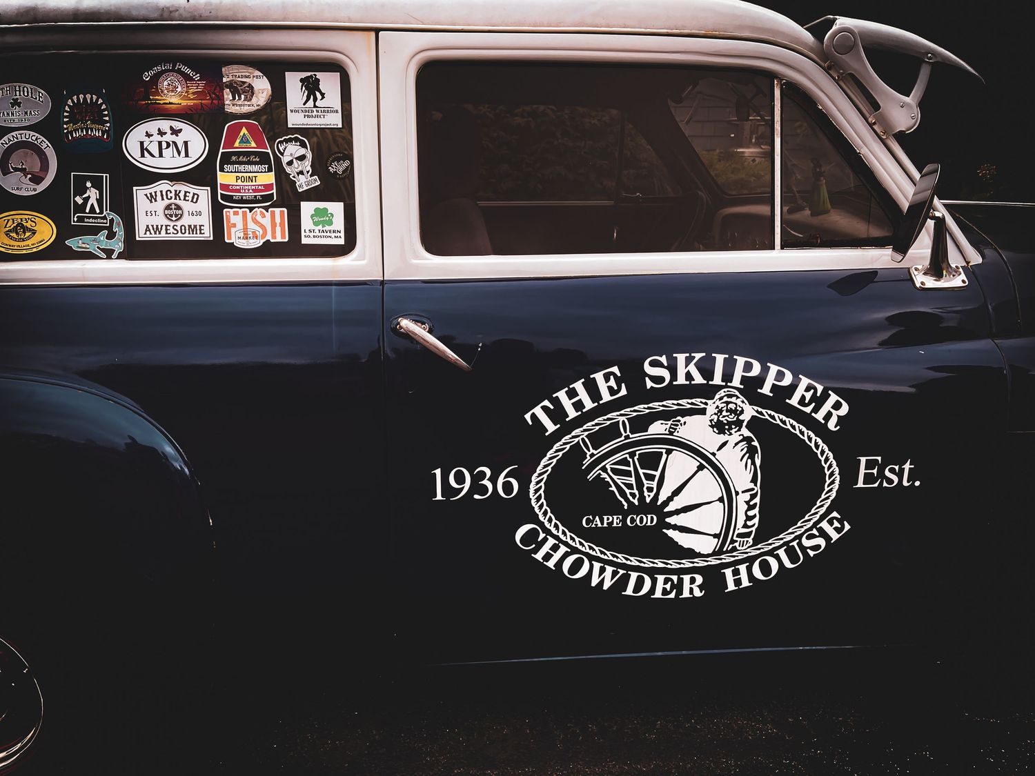 Vintage dark blue delivery truck door featuring The Skipper Chowder House Cape Cod Est. 1936 logo.