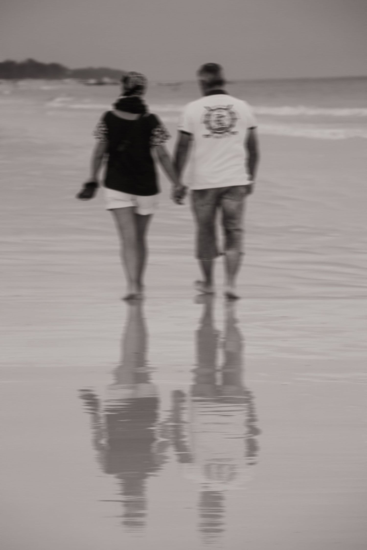 Aufnahme einer liebevollen Berührung zwischen zwei Menschen beim Laufen am Strand