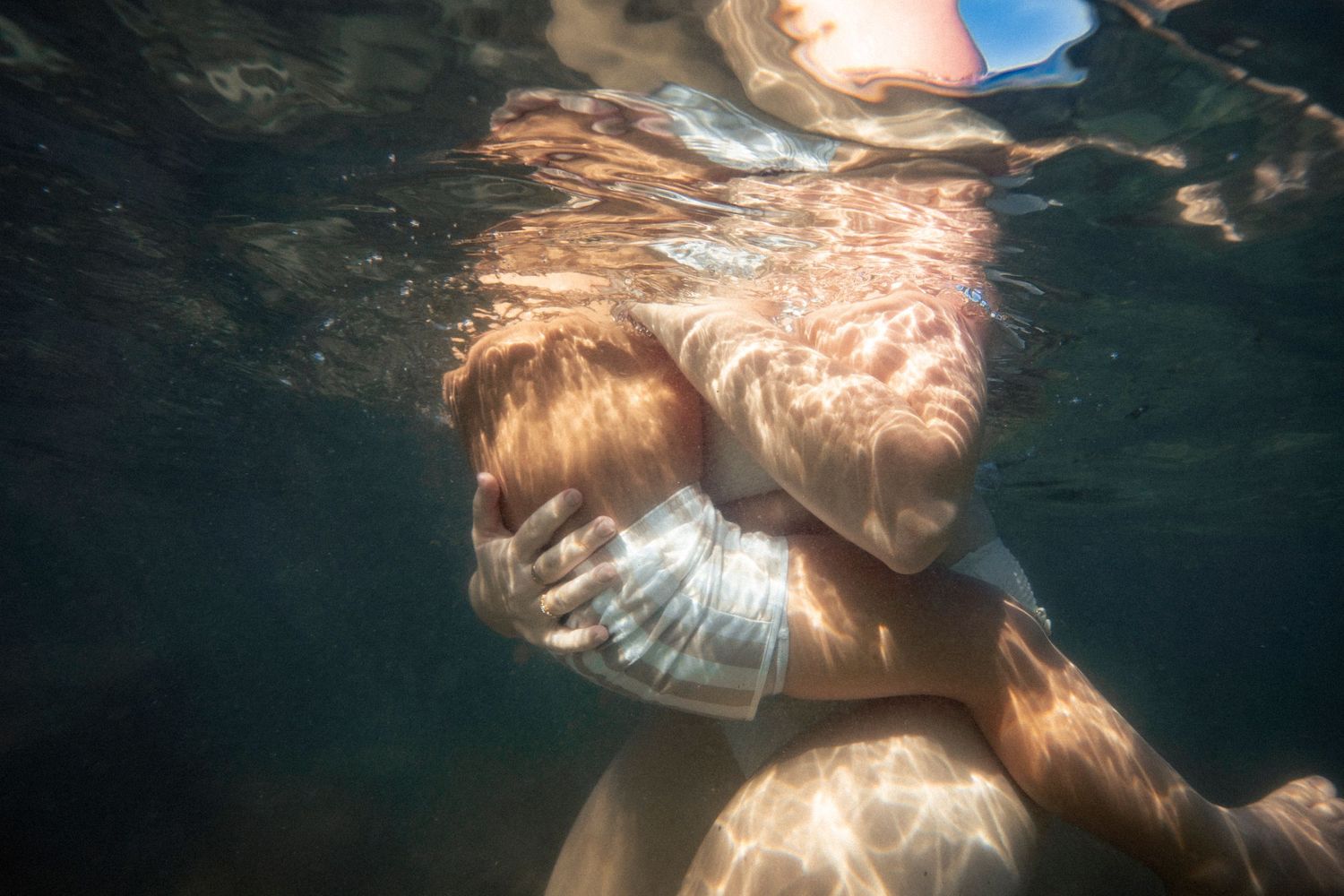 Cinematic underwater photo, in a documentary style, magical underwater photoshoot. Destination Elopement, maternity underwater photographer