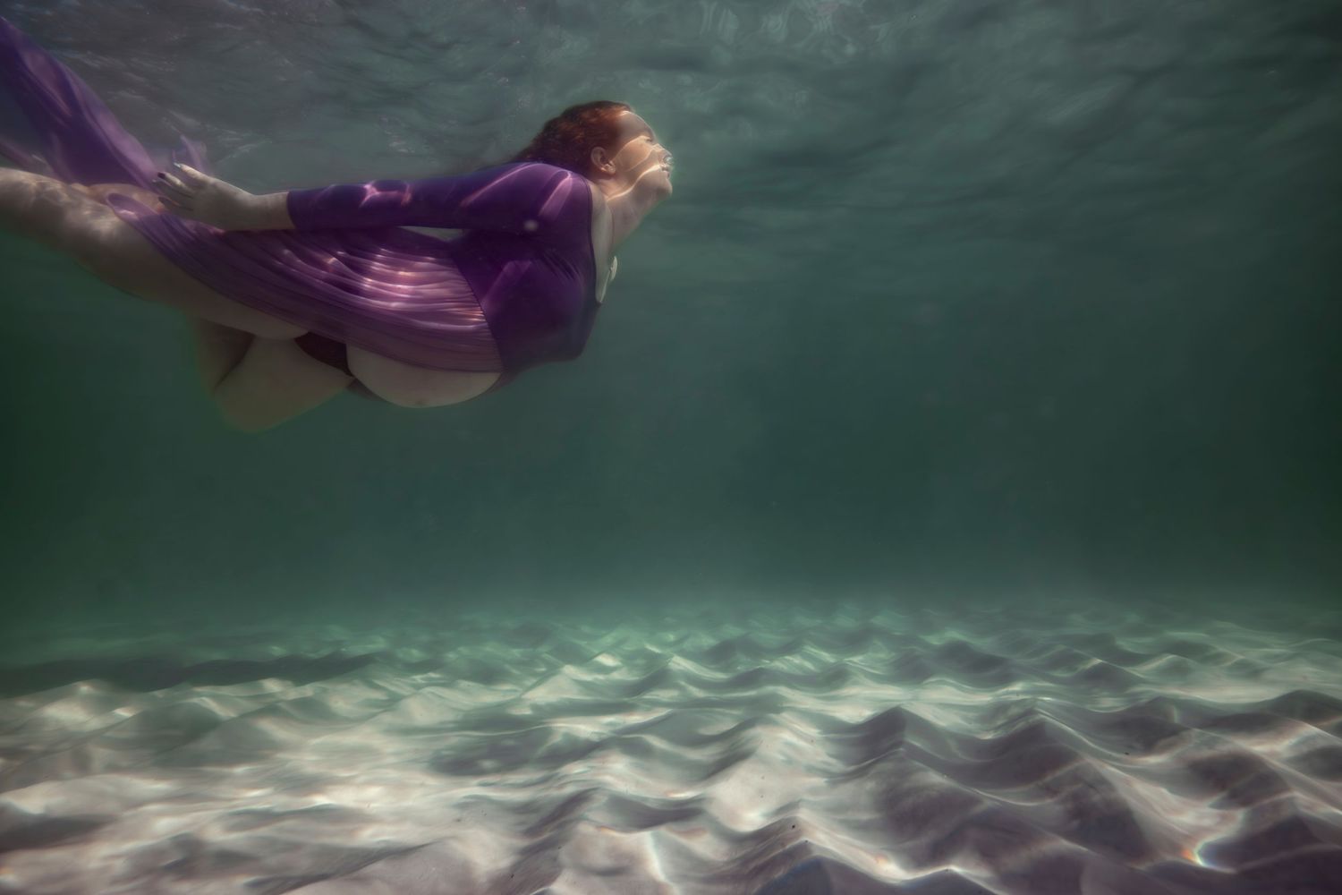 Cinematic underwater photo, in a documentary style, magical underwater photoshoot. Destination Elopement, maternity underwater photographer