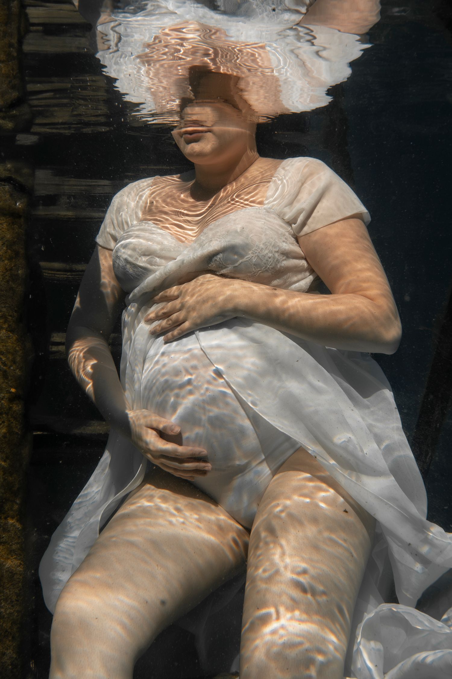 Cinematic underwater photo, in a documentary style, magical underwater photoshoot. Destination Elopement, maternity underwater photographer