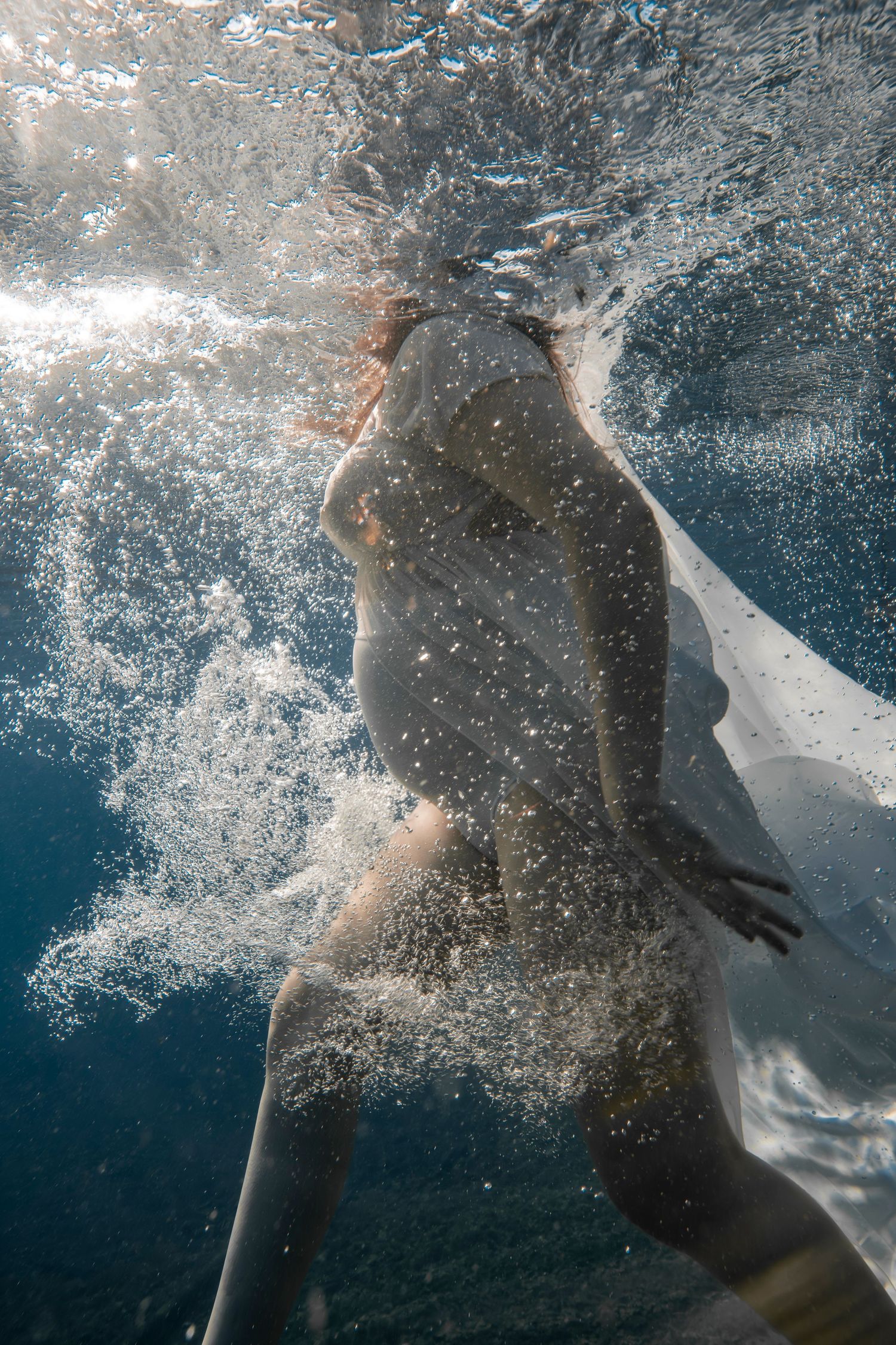 Cinematic underwater photo, in a documentary style, magical underwater photoshoot. Destination Elopement, maternity underwater photographer