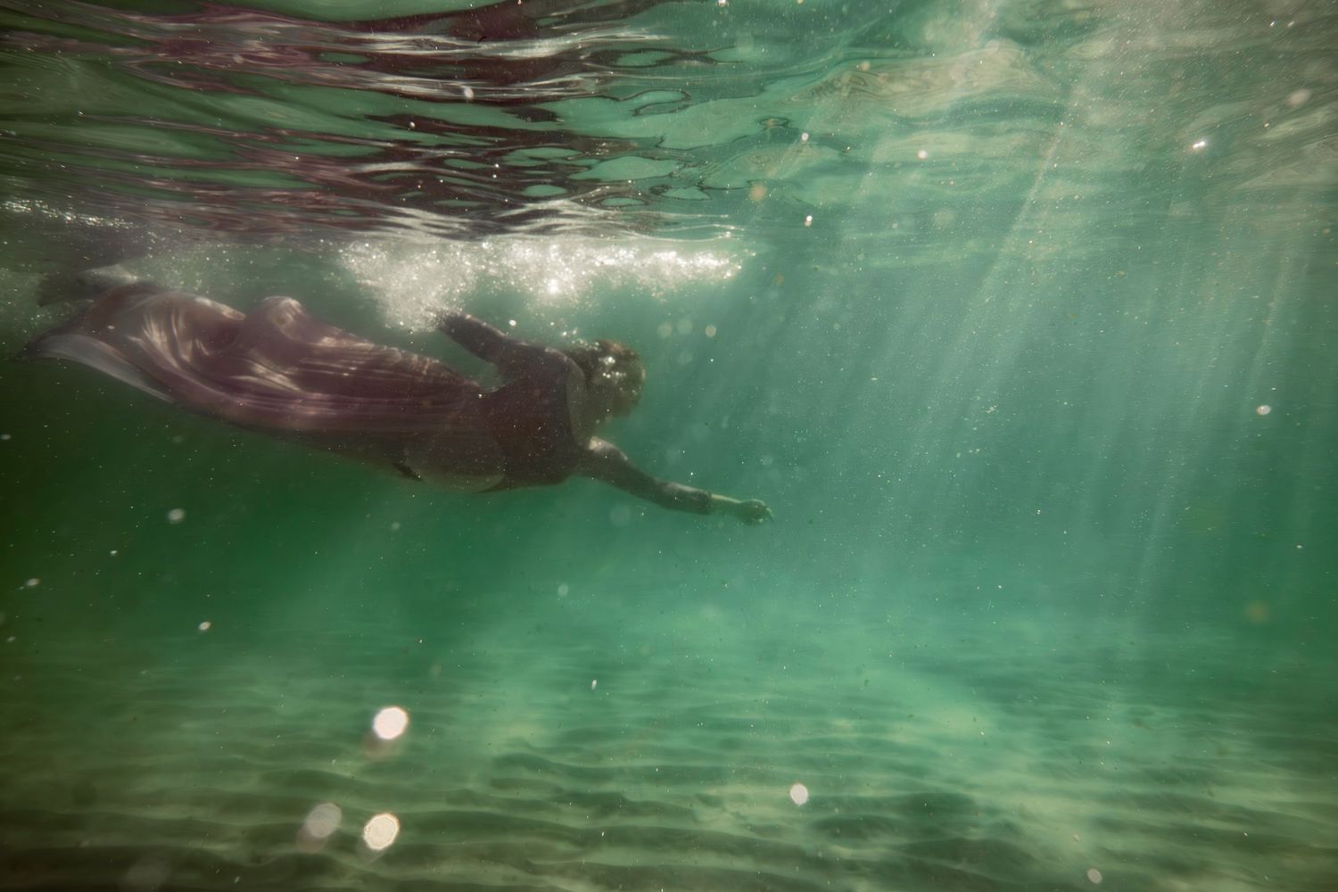 Cinematic underwater photo, in a documentary style, magical underwater photoshoot. Destination Elopement, maternity underwater photographer