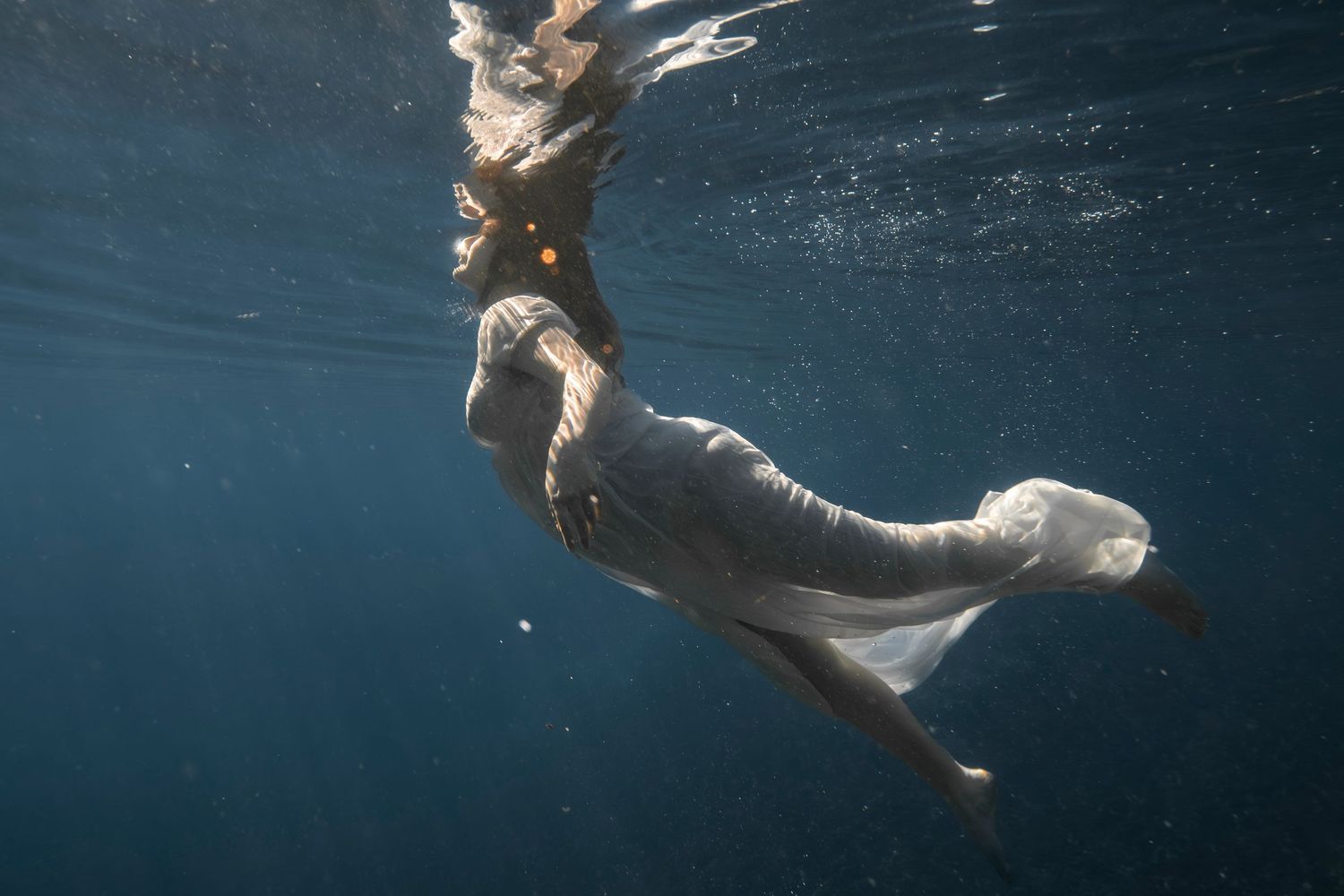 Cinematic underwater photo, in a documentary style, magical underwater photoshoot. Destination Elopement, maternity underwater photographer