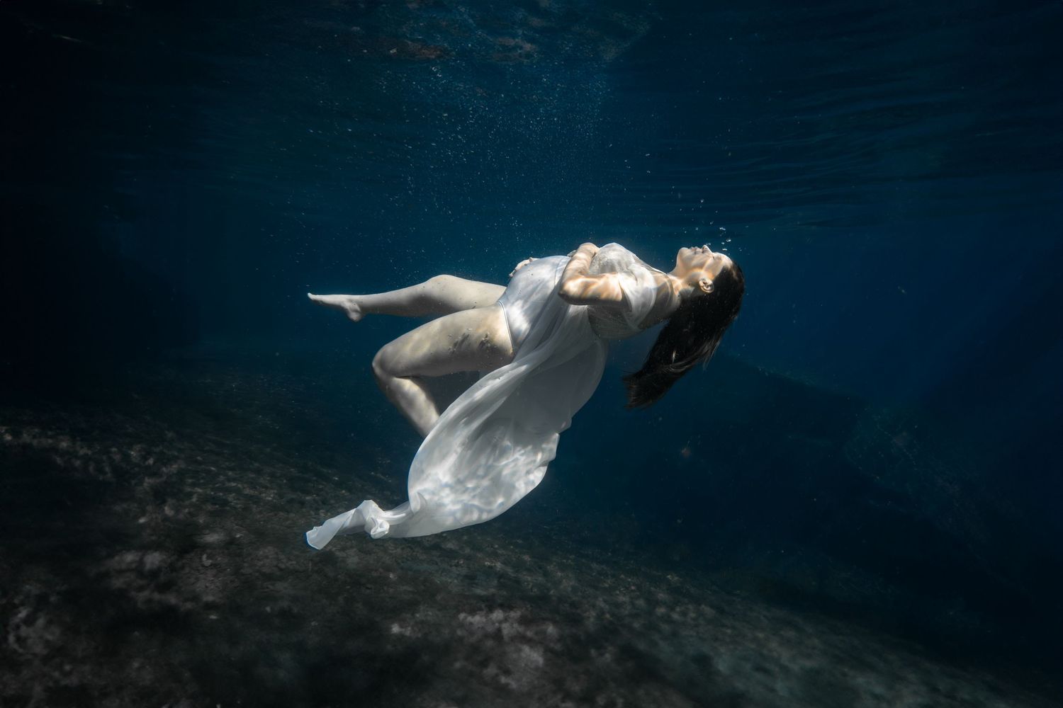 Cinematic underwater photo, in a documentary style, magical underwater photoshoot. Destination Elopement, maternity underwater photographer