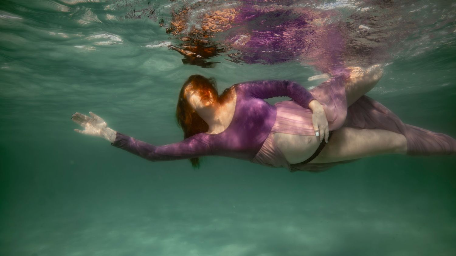 Cinematic underwater photo, in a documentary style, magical underwater photoshoot. Destination Elopement underwater photographer