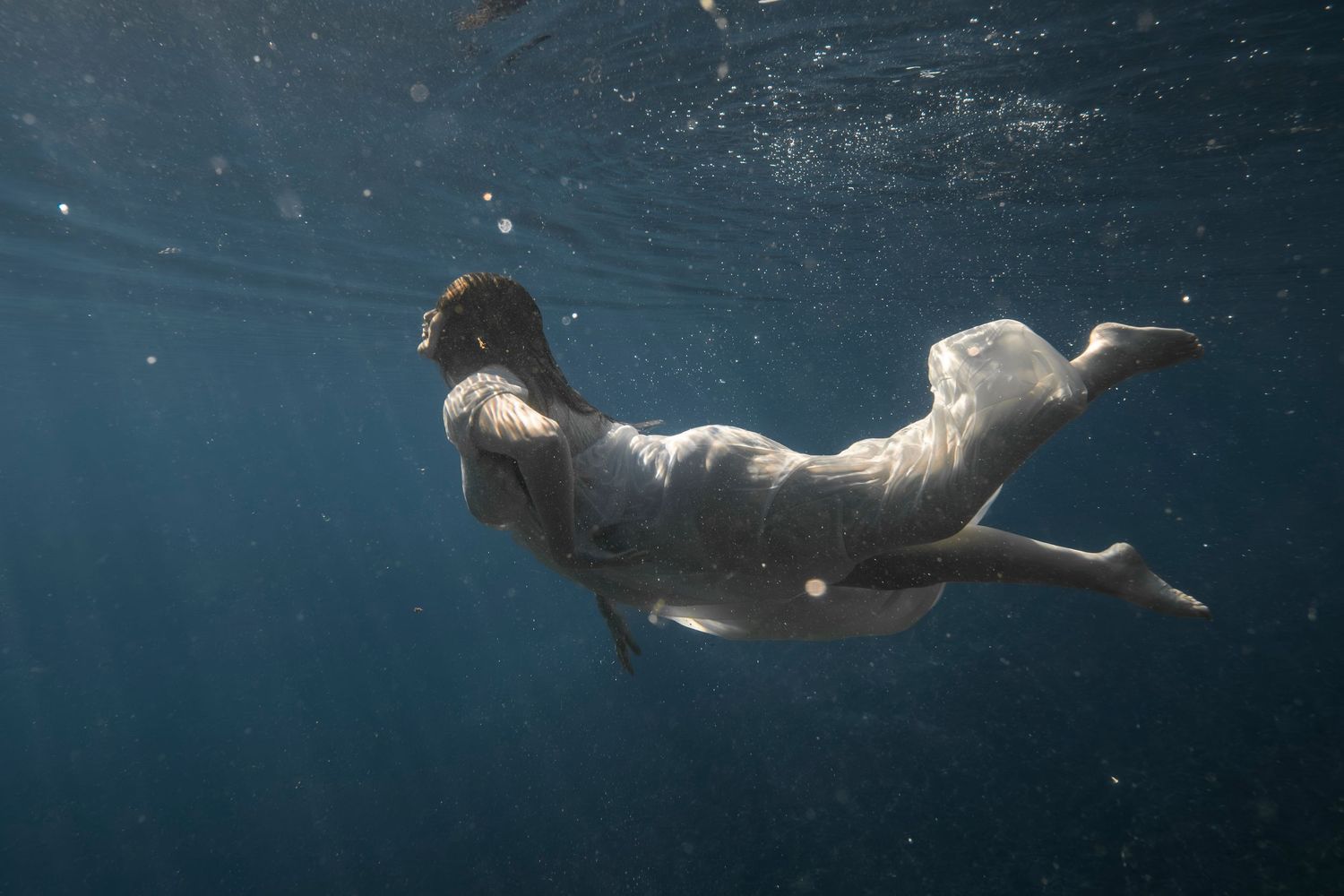 Cinematic underwater photo, in a documentary style, magical underwater photoshoot. Destination Elopement, maternity underwater photographer
