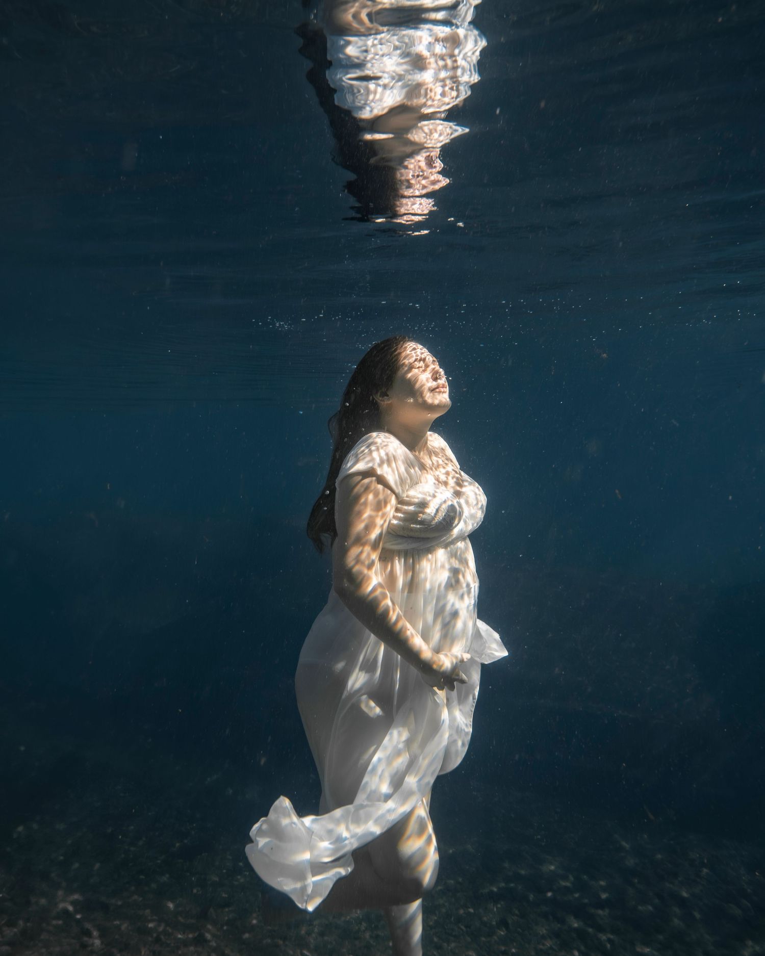 Cinematic underwater photo, in a documentary style, magical underwater photoshoot. Destination Elopement, maternity underwater photographer