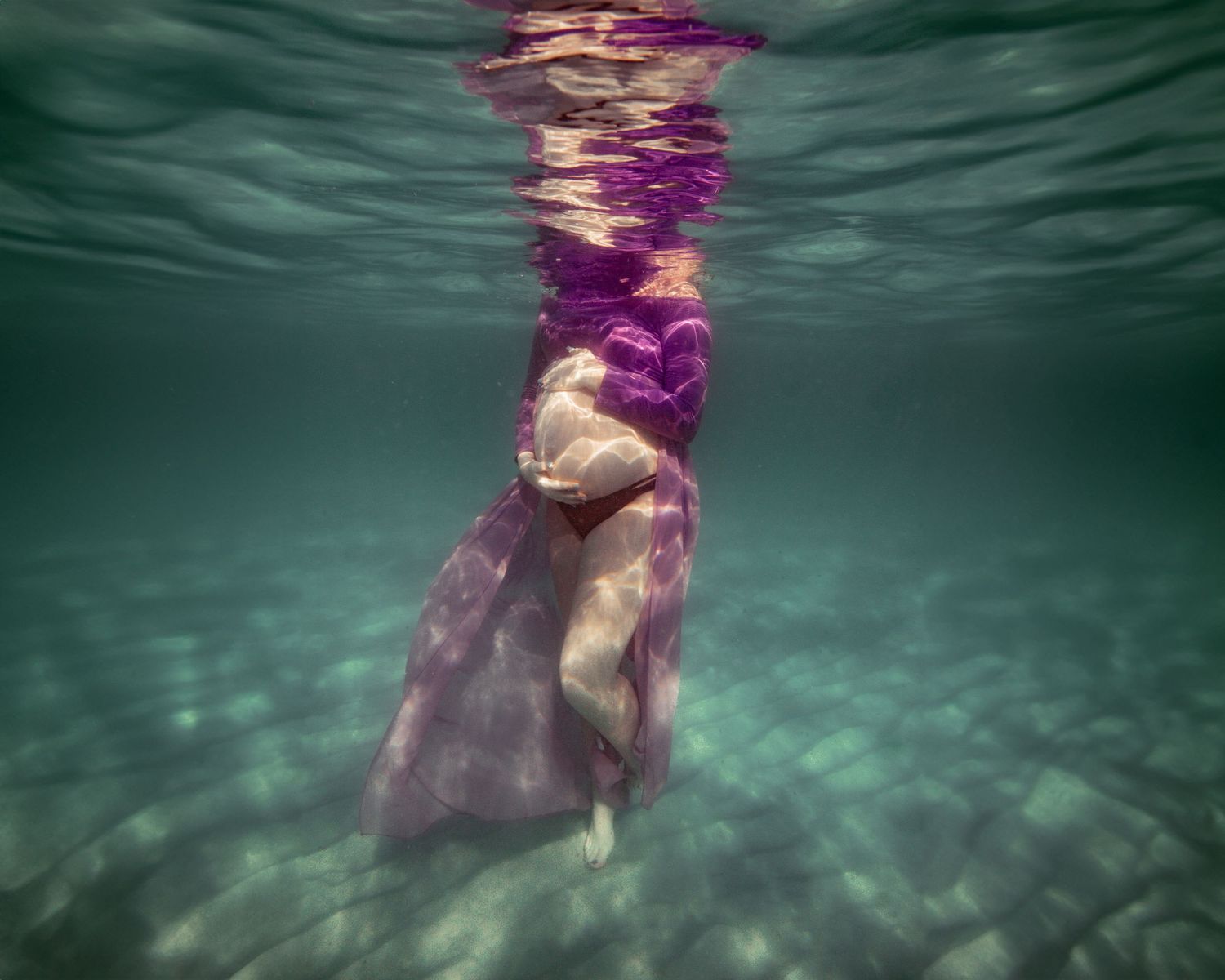 Cinematic underwater photo, in a documentary style, magical underwater photoshoot. Destination Elopement, maternity underwater photographer