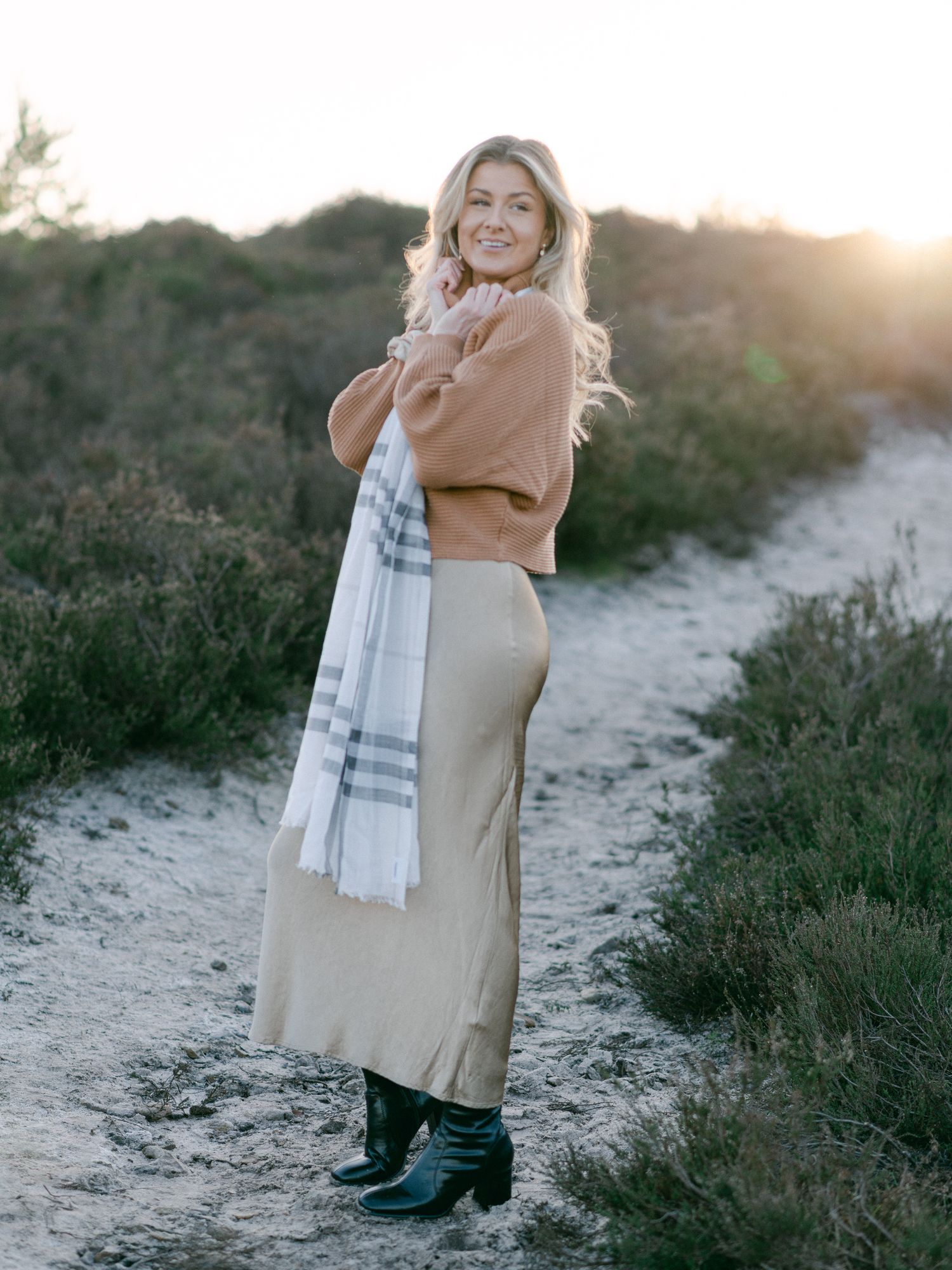 Person in casual outfit enjoying sunset on a nature path.