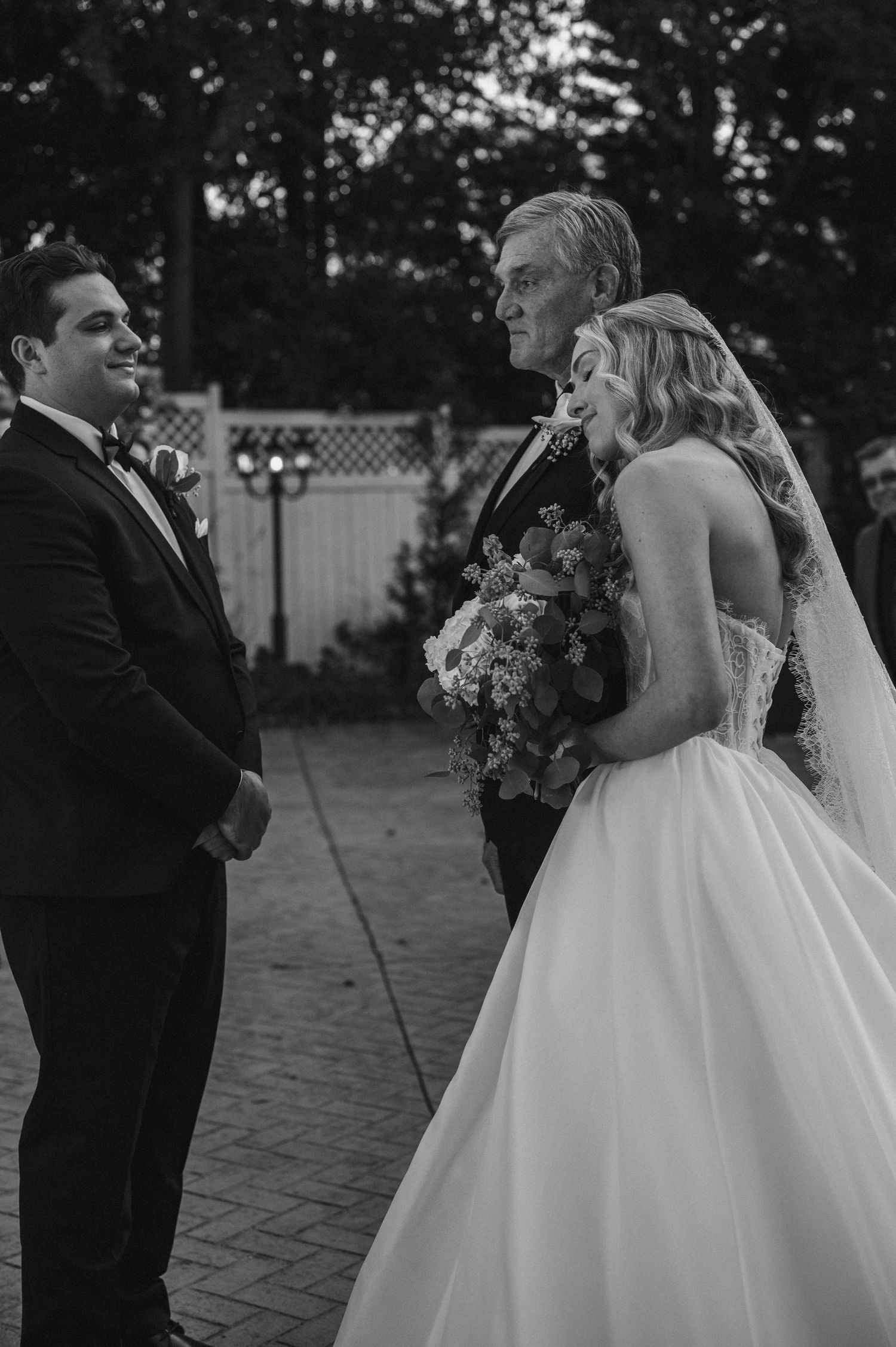 Black and white wedding sequence shows a tender moment between newlyweds during their first dance outdoors.