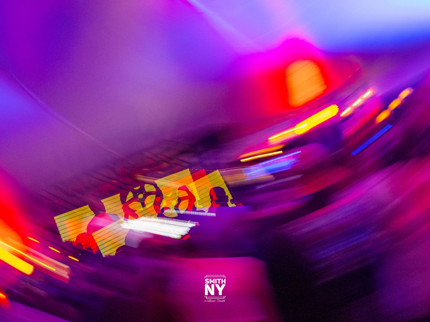 Abstract motion blur photography with vibrant purple, pink, and yellow light streaks creating dynamic swirling patterns.