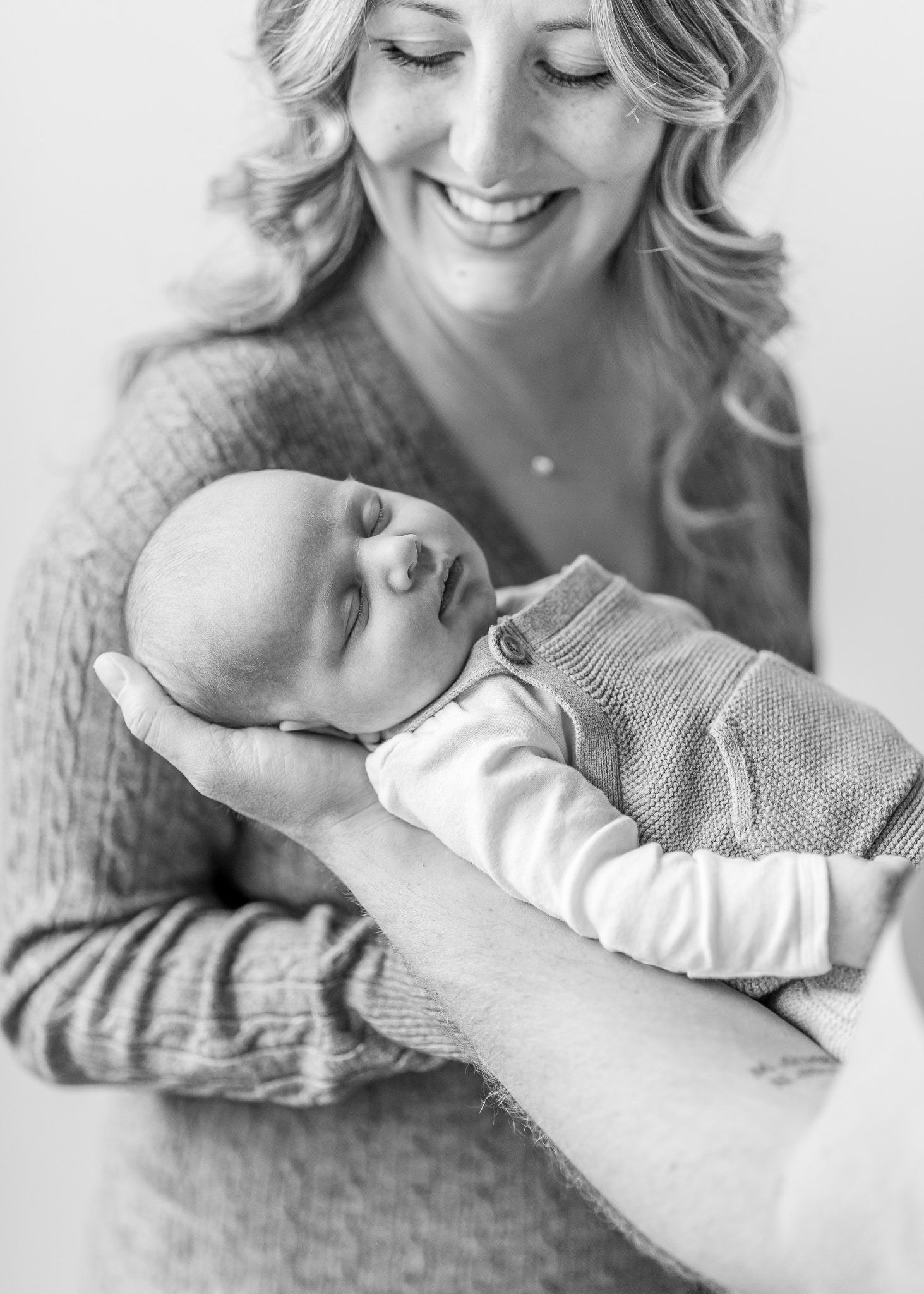 Black and white portrait series showing tender moments between mother and newborn.