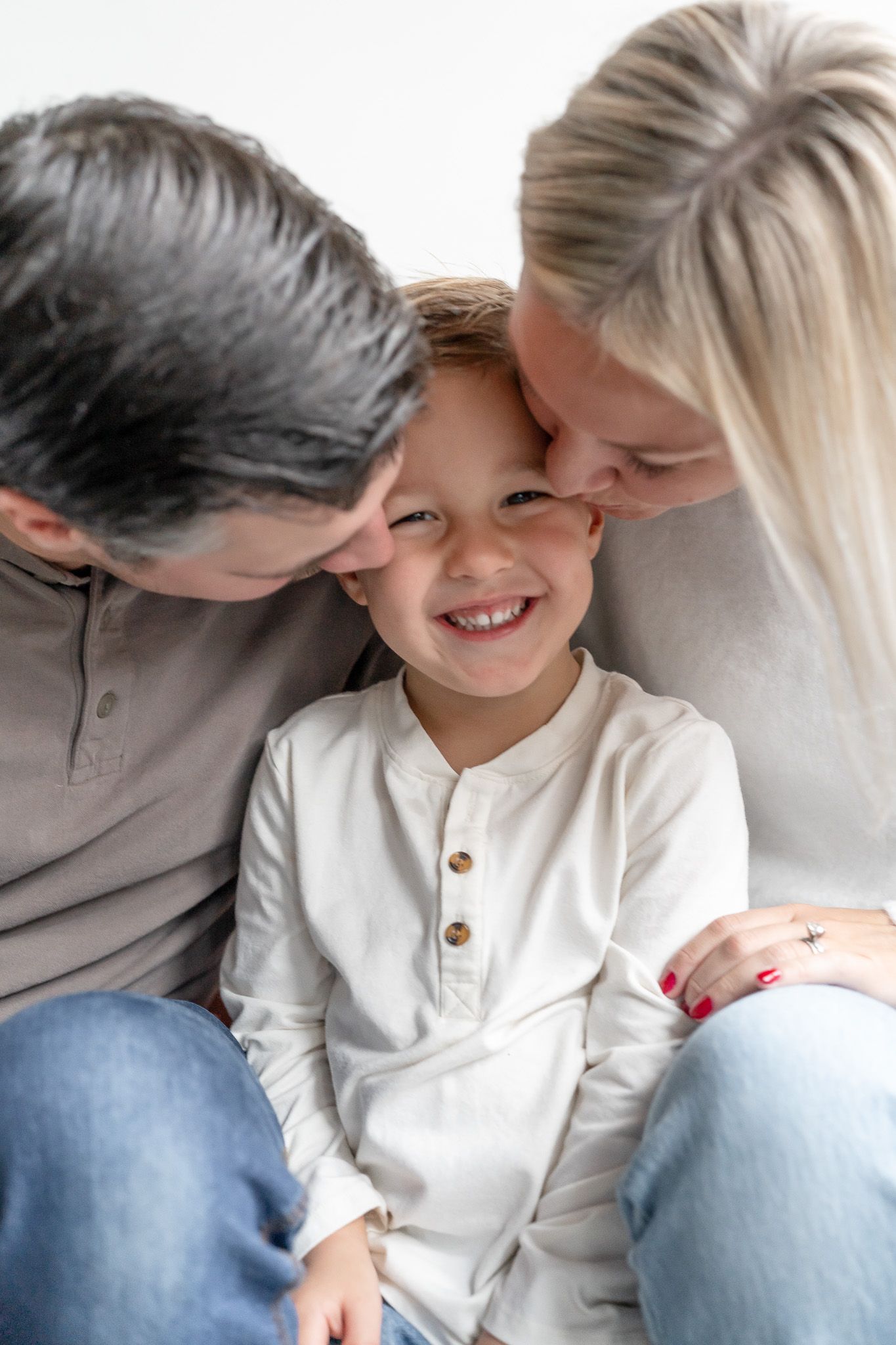 A tender moment between parent and child sharing laughter while sitting together in casual clothing.