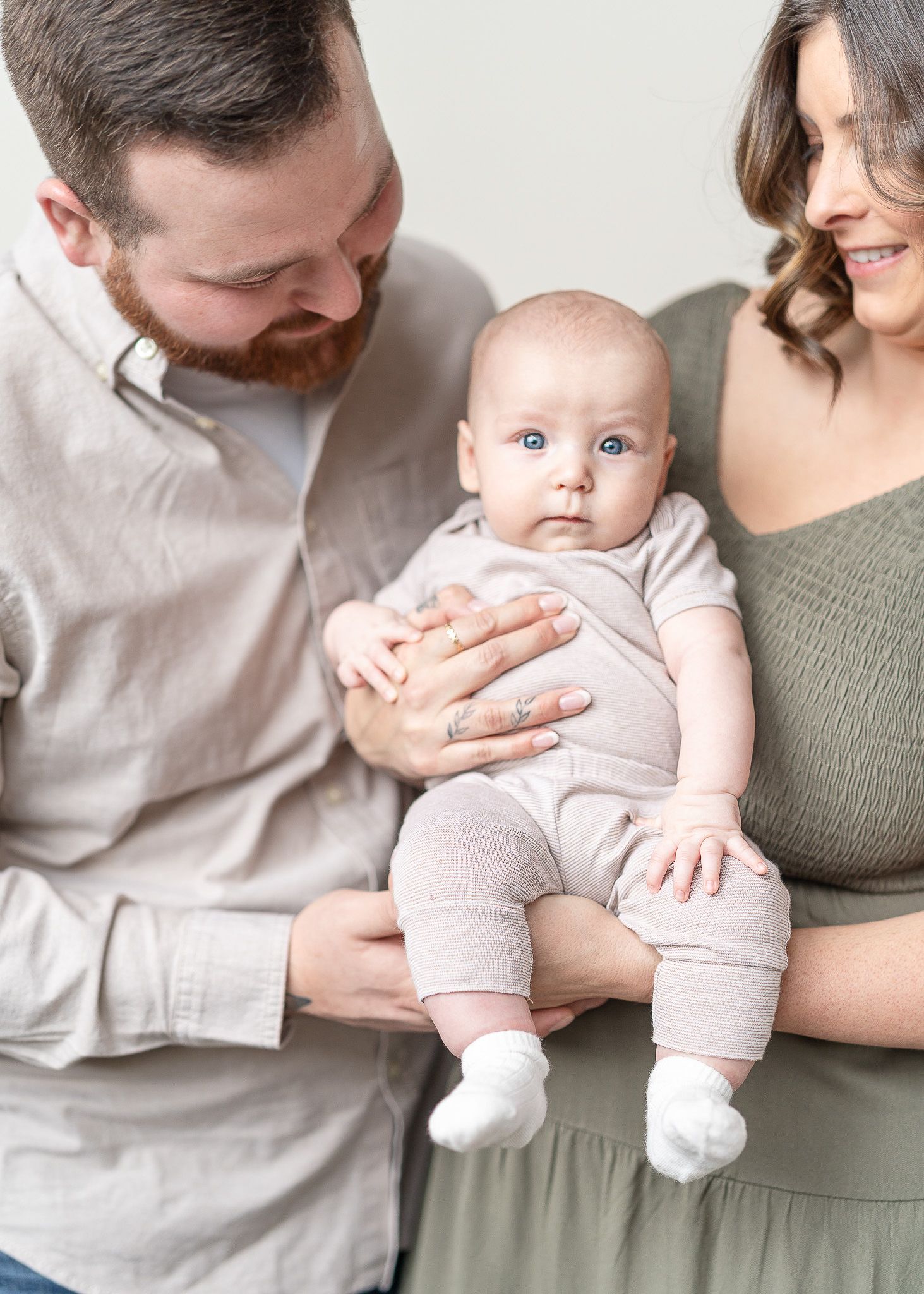 A series of five connected photos showing tender family moments with a baby in soft neutral tones.