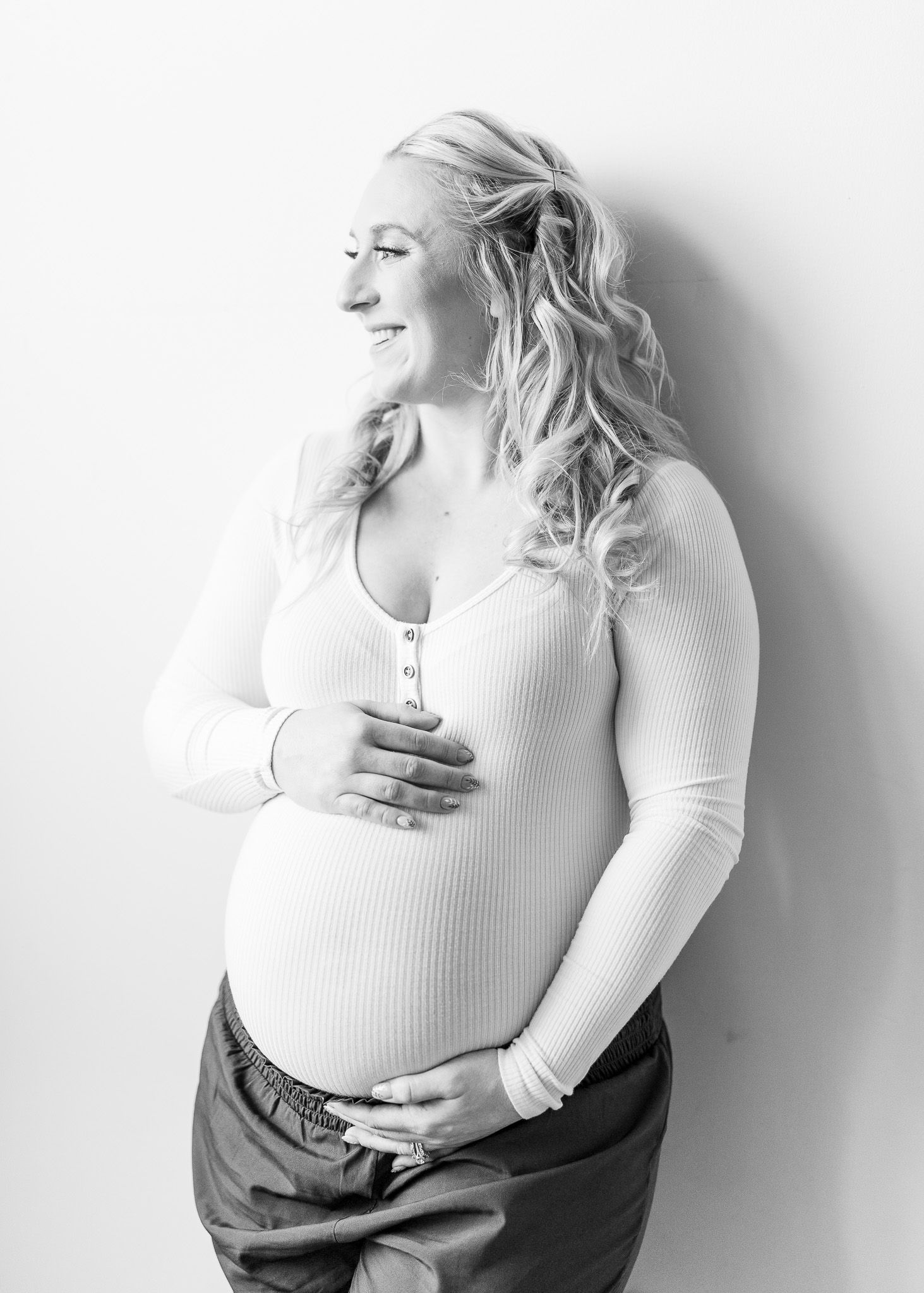 Black and white artistic portrait series showing a person in a white top posing expressively against a light background.
