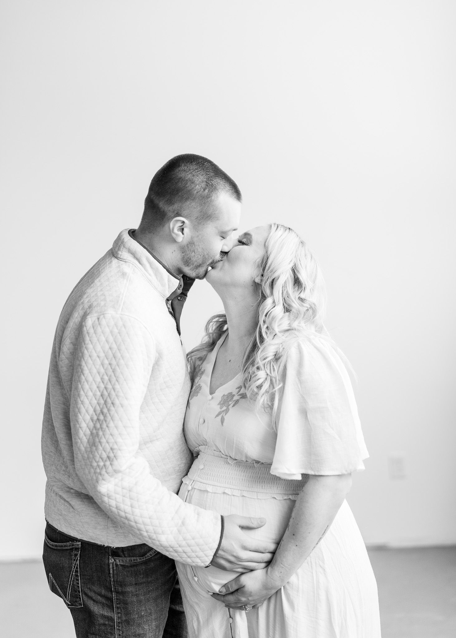 A romantic black and white portrait of a couple sharing an intimate moment in casual attire.