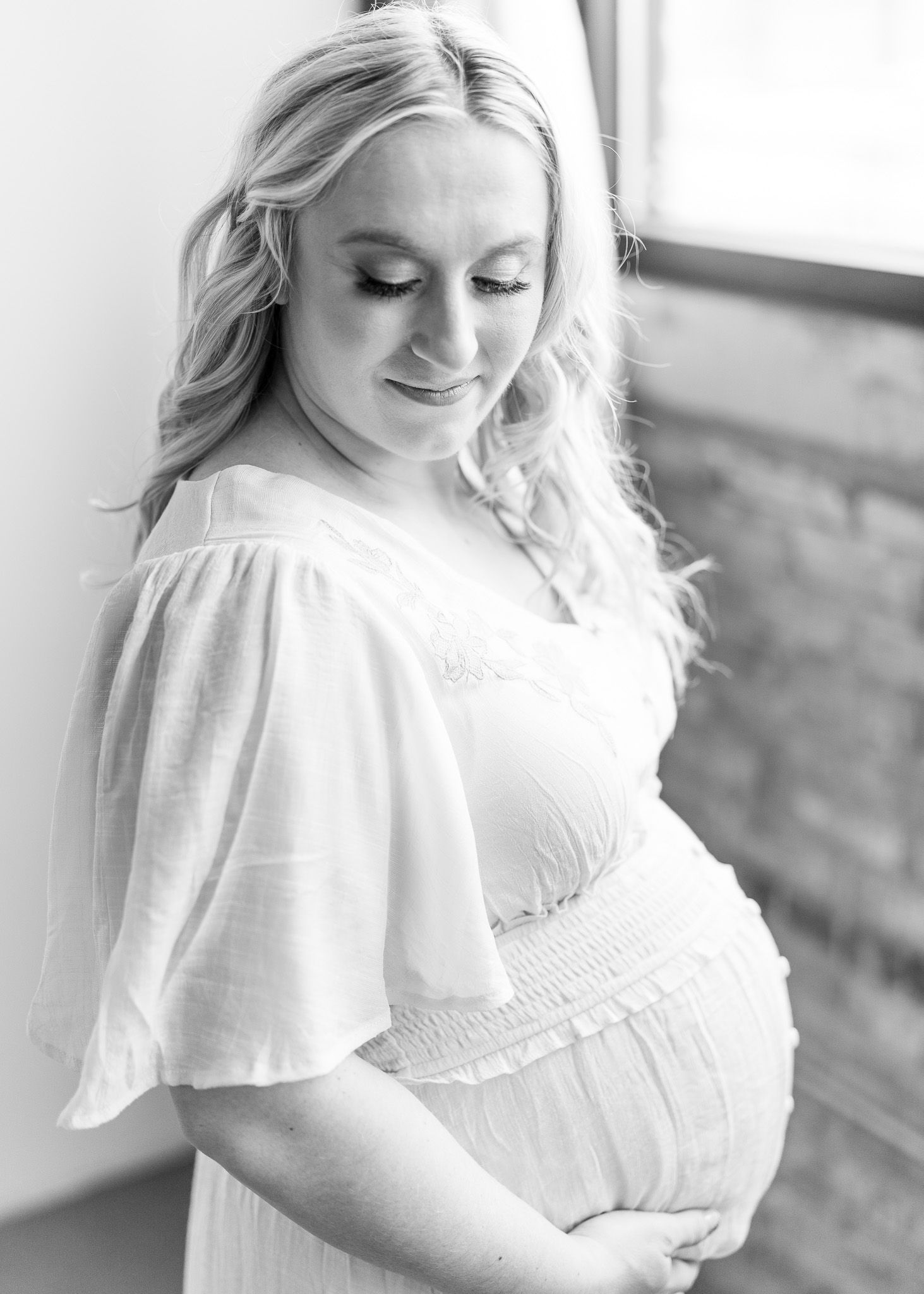 A woman in a white ruffled dress poses against a rustic wall in a series of soft, romantic portraits.