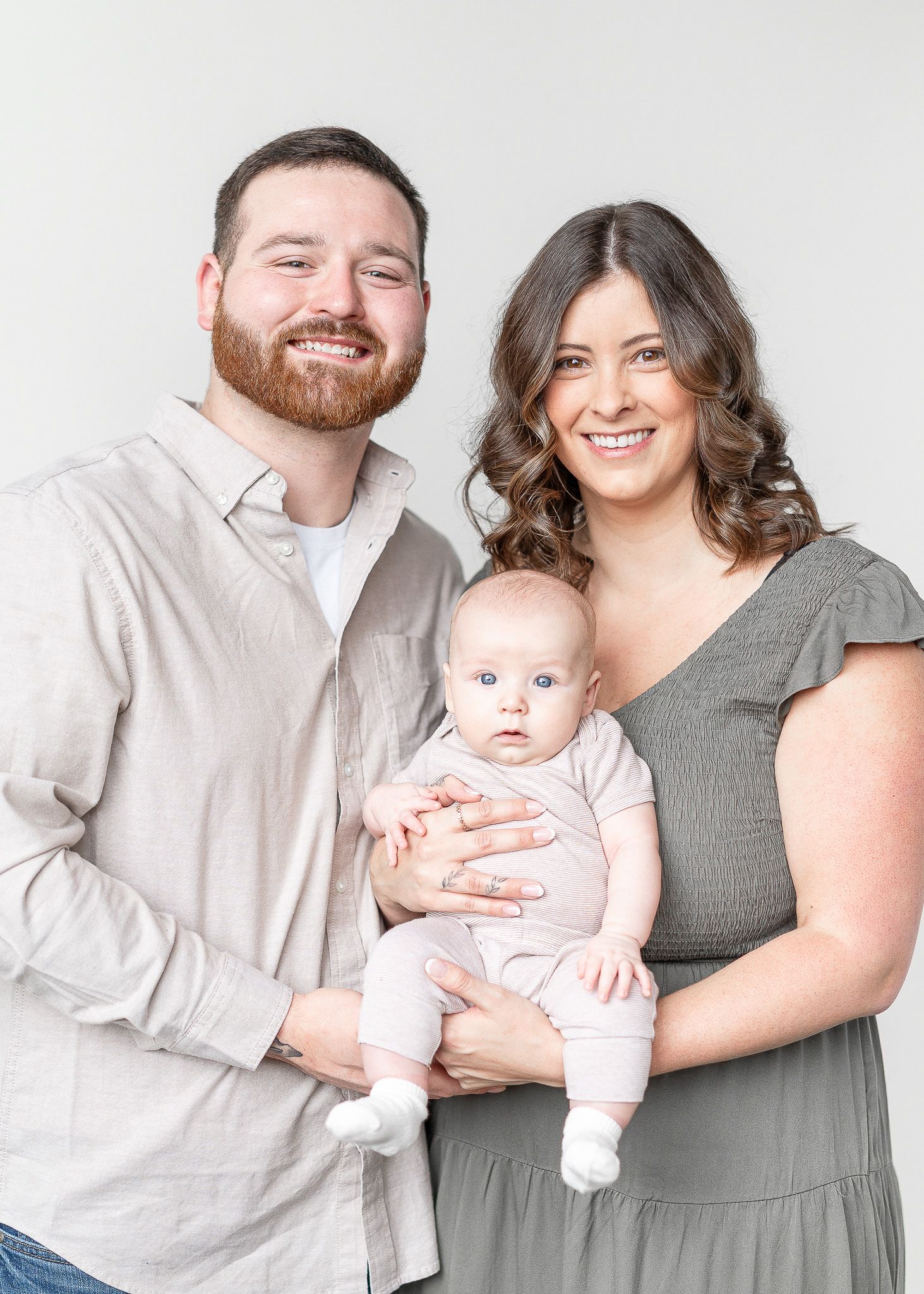 A collection of family portrait poses against a white backdrop in coordinated outfits.