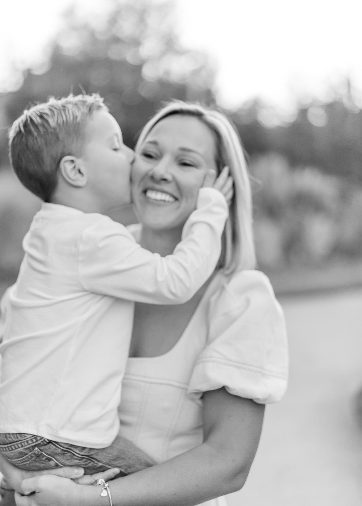 A tender black and white photo series showing a mother and child sharing playful, joyful moments together.