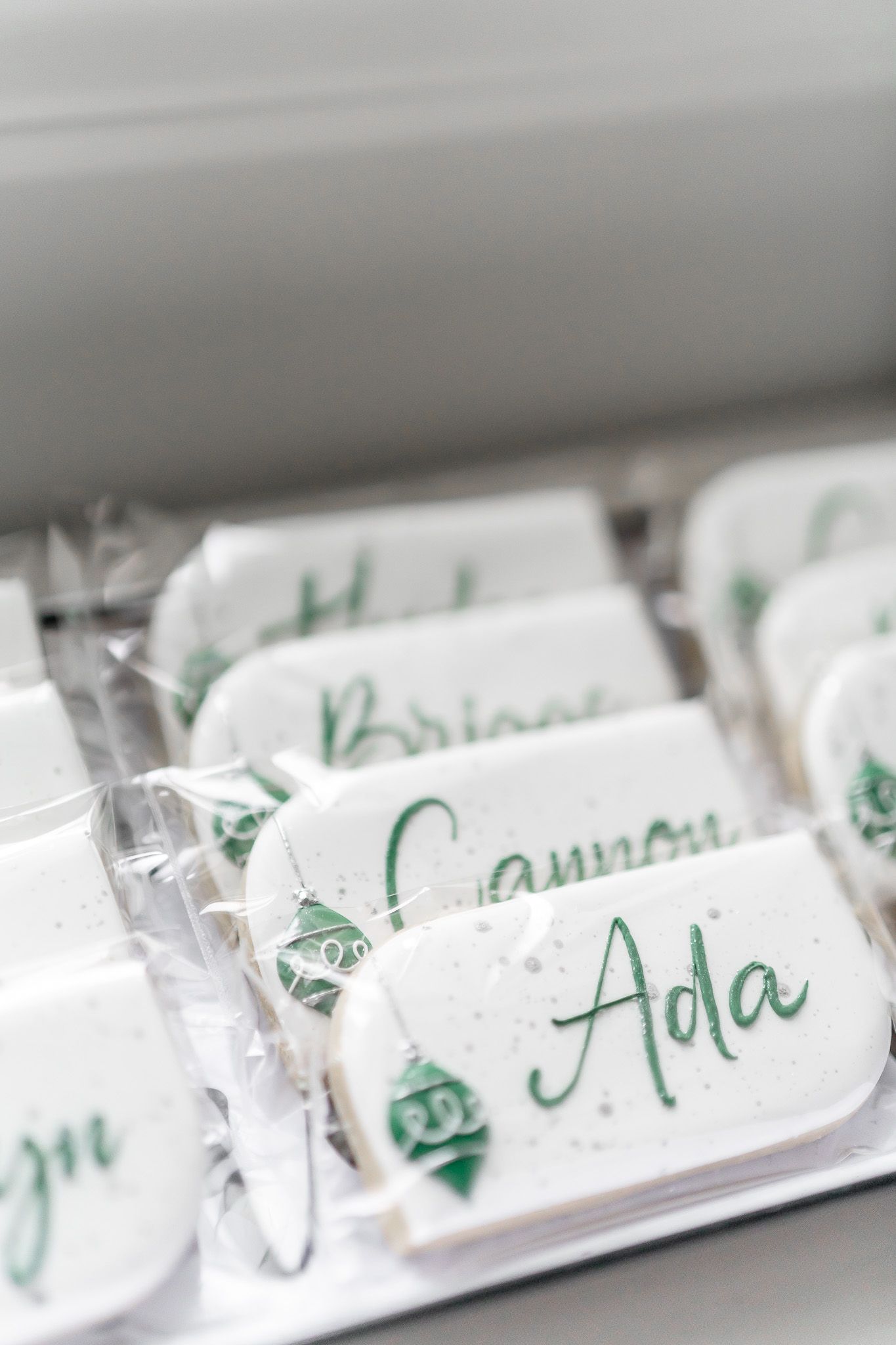 Close-up of elegant name cards with green script lettering for holiday place settings.