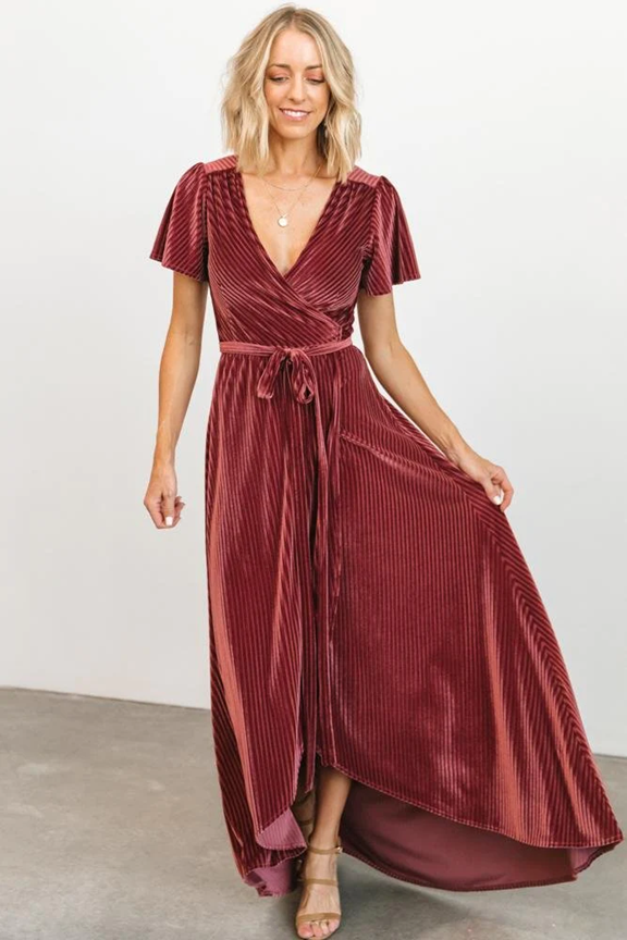 Burgundy velvet wrap dress with flutter sleeves shown in various poses against white backdrop.