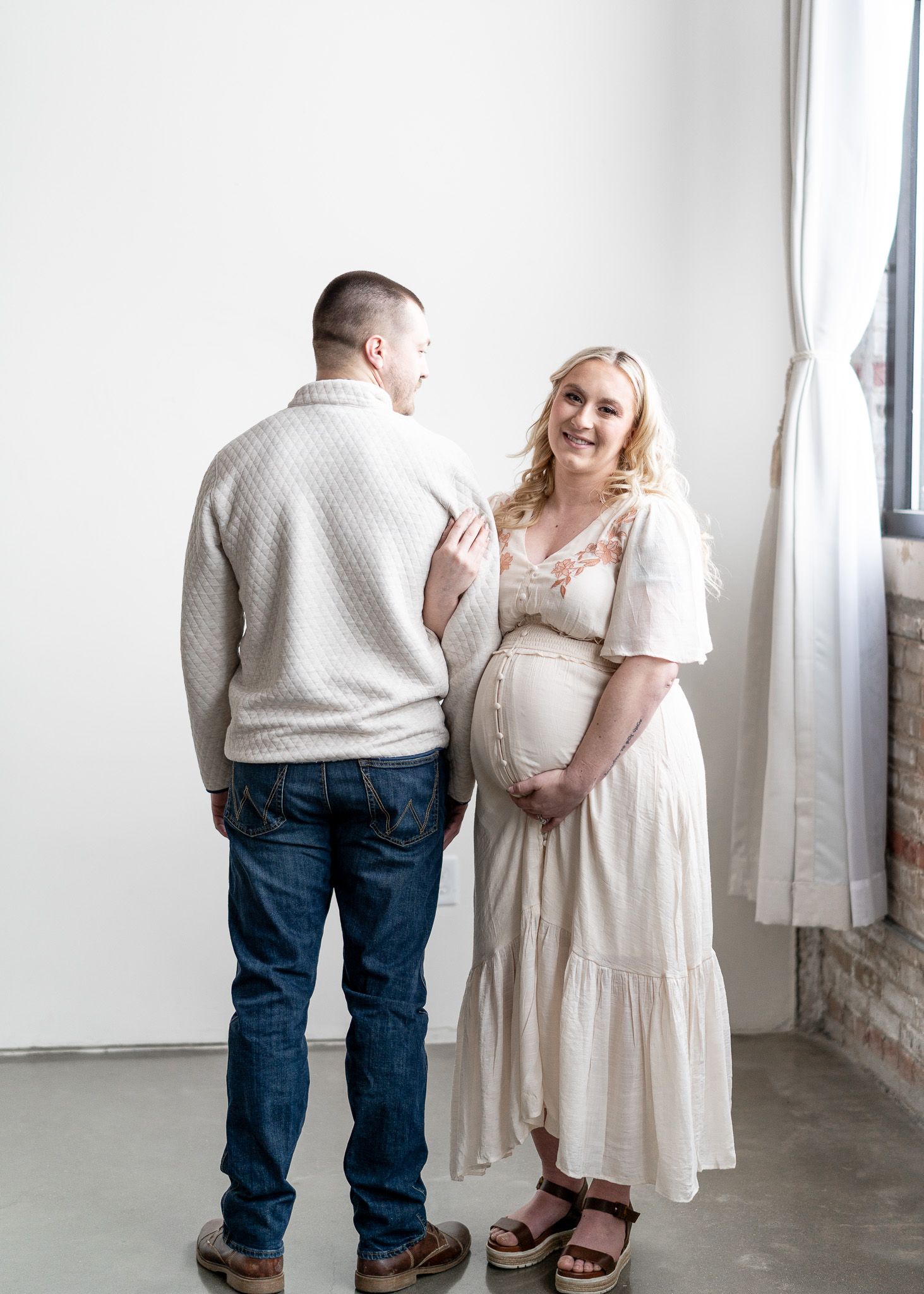 A series of intimate dance poses showing a couple in casual attire against a white wall.