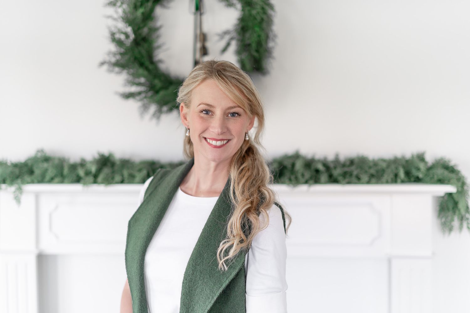 Modern white room with holiday greenery decorations and natural lighting.