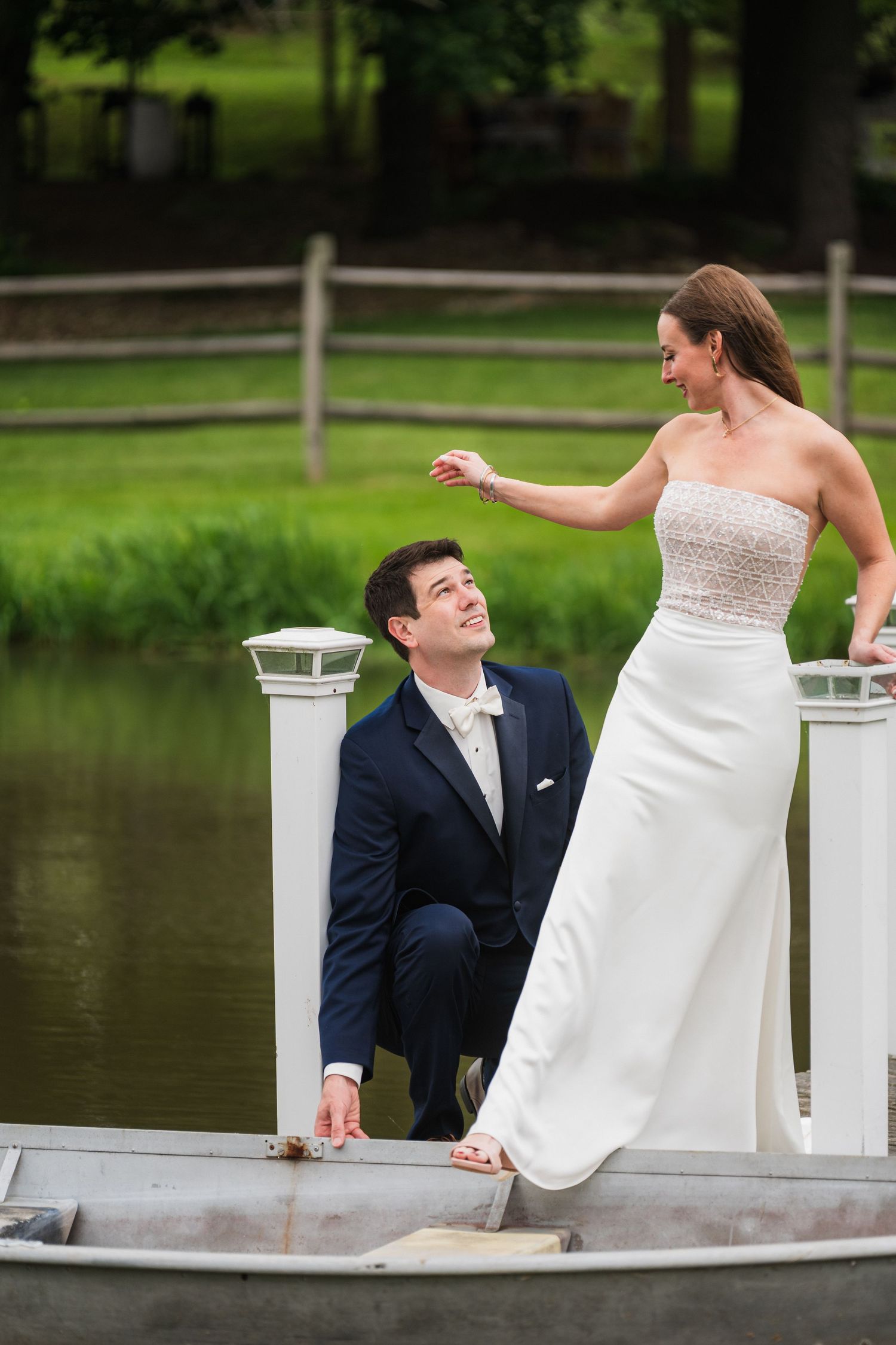 A couple sharing a playful moment on a wooden dock by a pond  at shady elms farm pittsburgh pa photography and video.