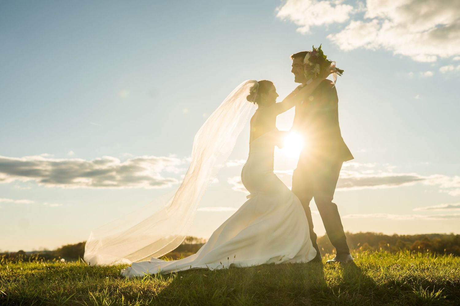 Couple during outdoor engagement photography session at Renshaw Farms, Freeport, PA, golden fields and rustic barn in the background.
