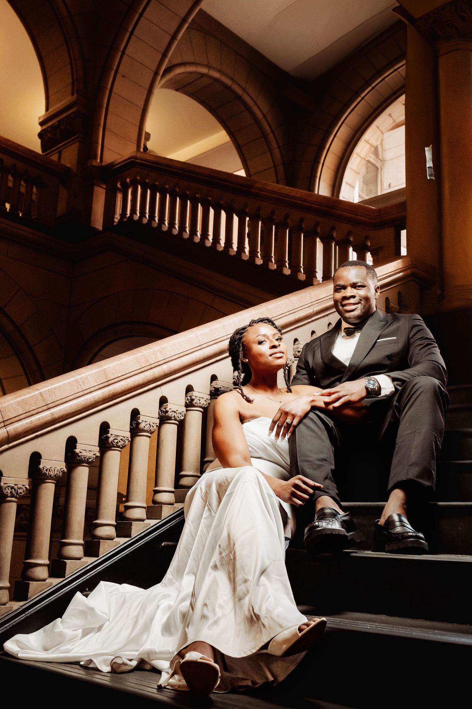 Couple during engagement photography session at Allegheny County Courthouse, Pittsburgh, PA, stone arches and grand historic architecture.