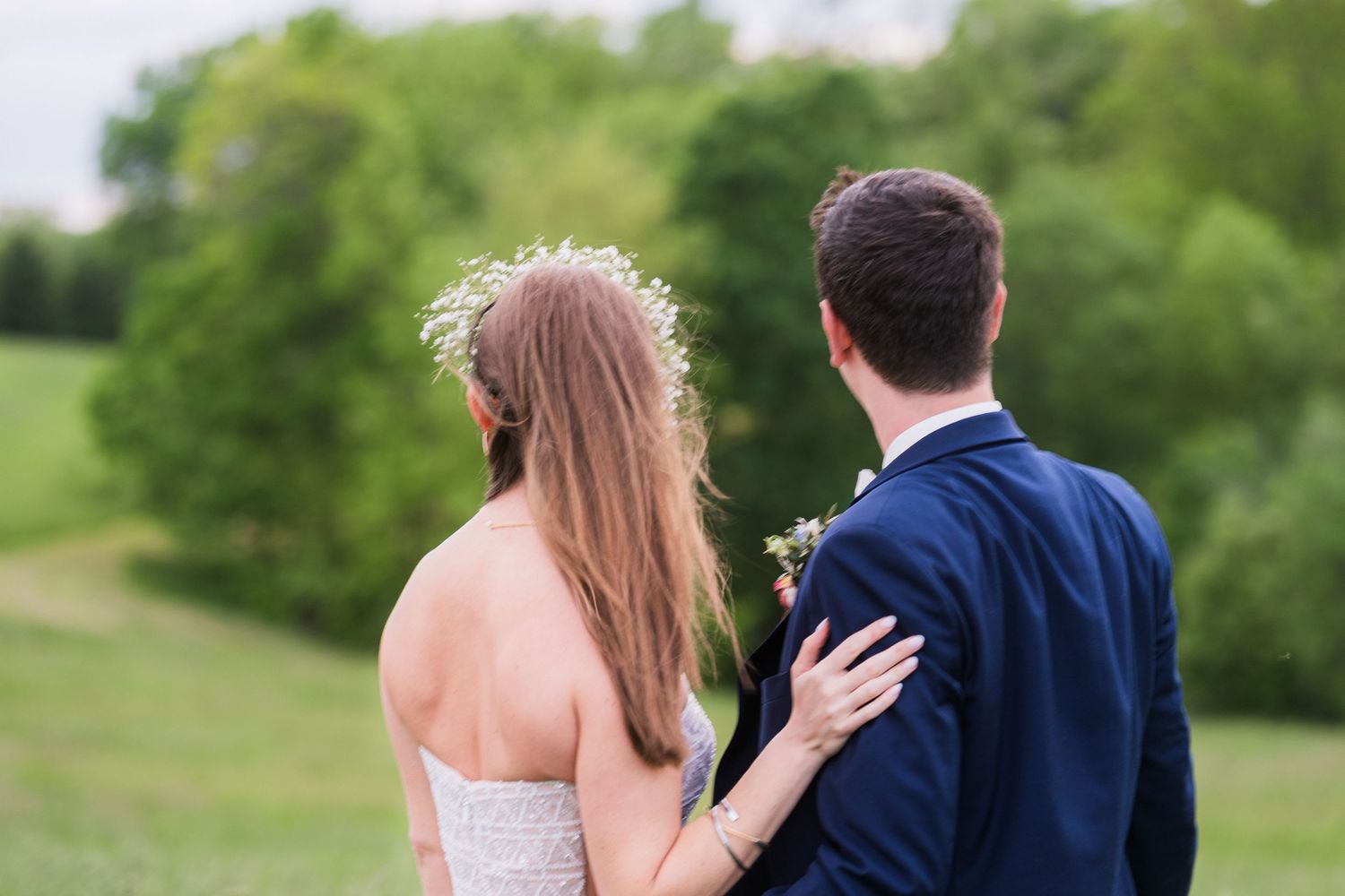 Couple enjoys intimate moment together on rolling green hillside.