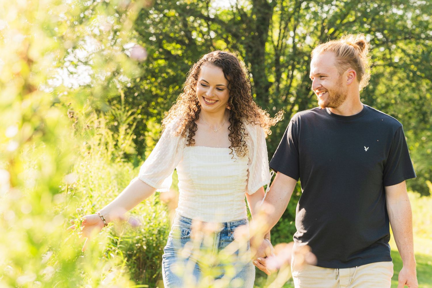 Couple embracing at golden hour during outdoor engagement session at Succop Nature Park, PA, glowing sunset bokeh background.
