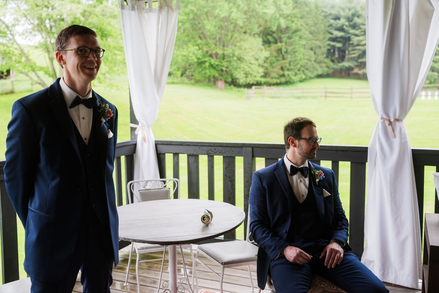 Two people in formal attire preparing in a covered outdoor venue with white drapes.  at shady elms farm pittsburgh pa photography and video