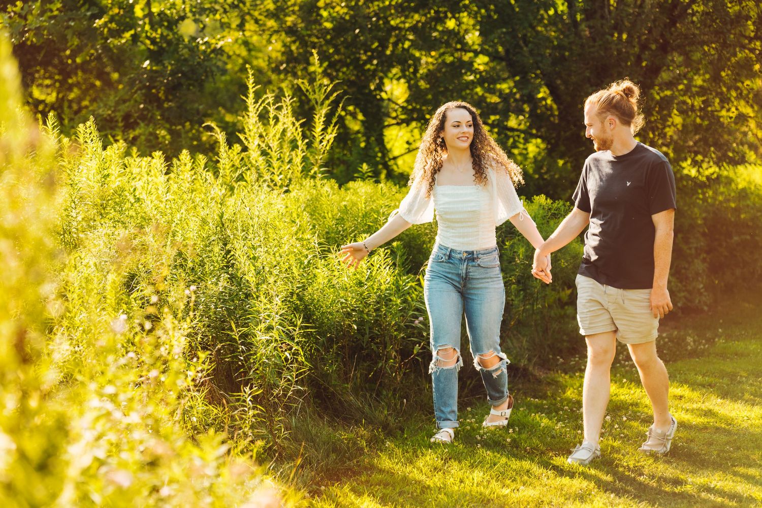 Couple during golden hour engagement photography session at Succop Nature Park, Butler, PA, warm sunset light filtering through the trees.