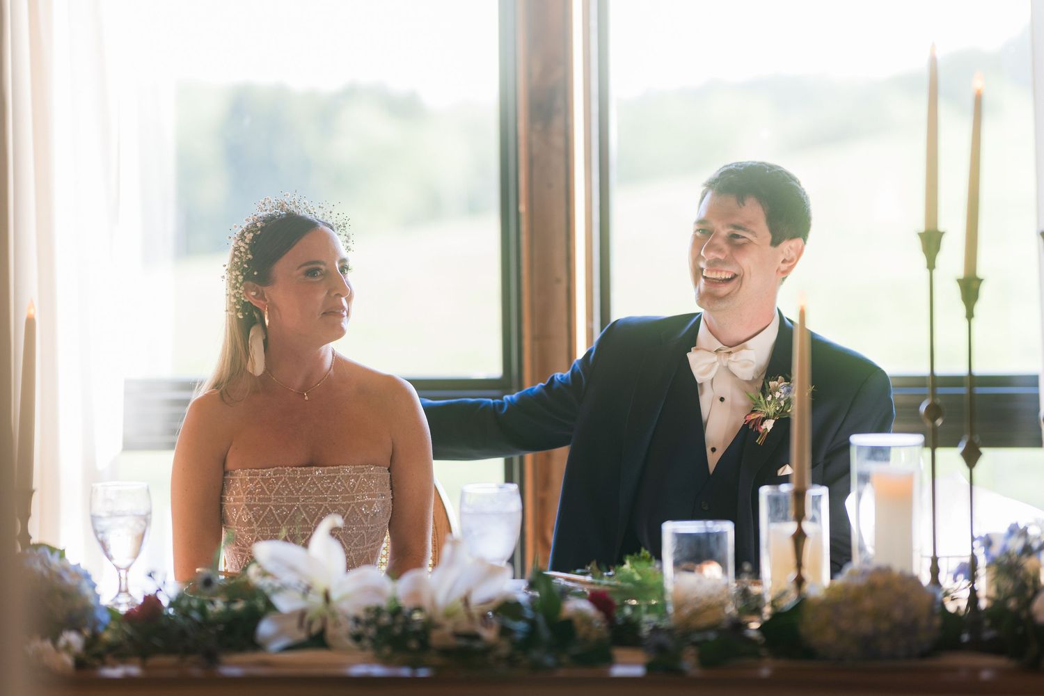 A candid moment of laughter captured at a wedding reception table.