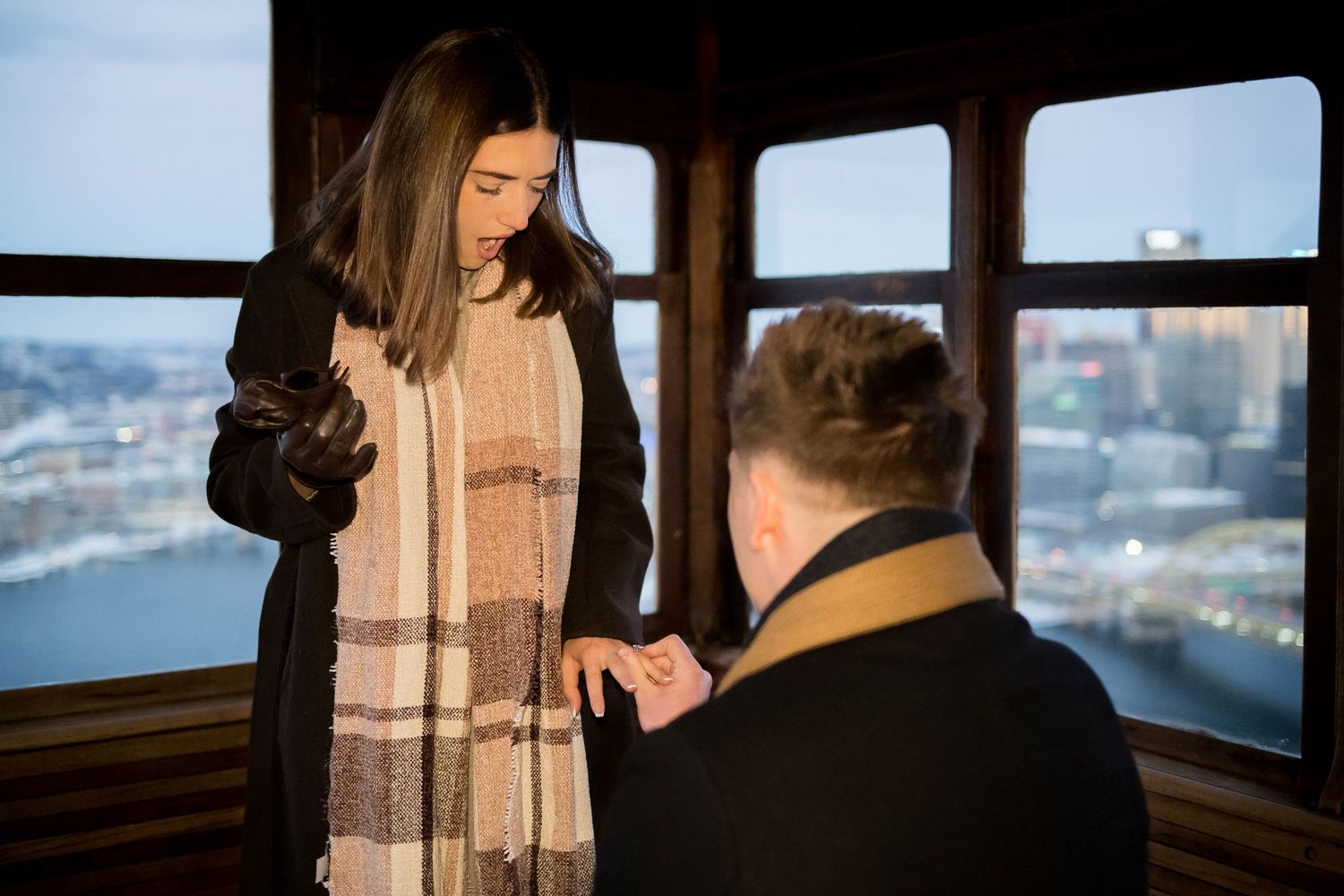 Couple during engagement photography session at Duquesne Incline overlook, Pittsburgh, PA, with iconic city skyline in the background.