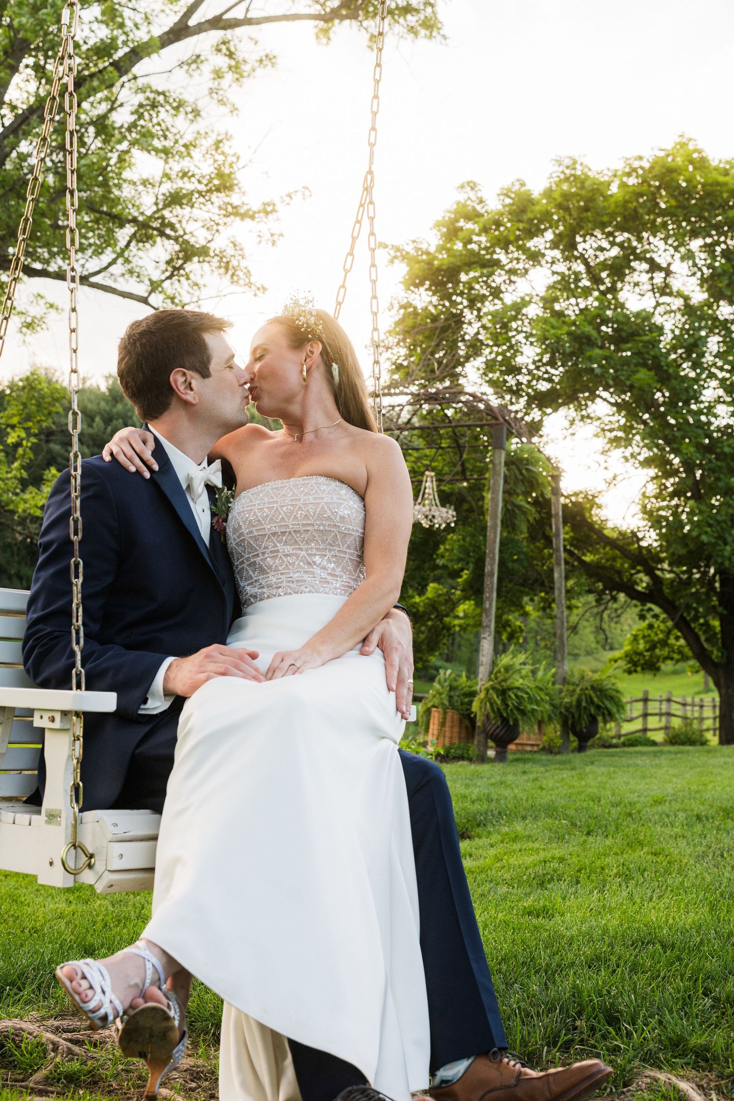 Romantic couple shares intimate moment on a wooden swing during sunset at their wedding.  at shady elms farm pittsburgh pa photography and