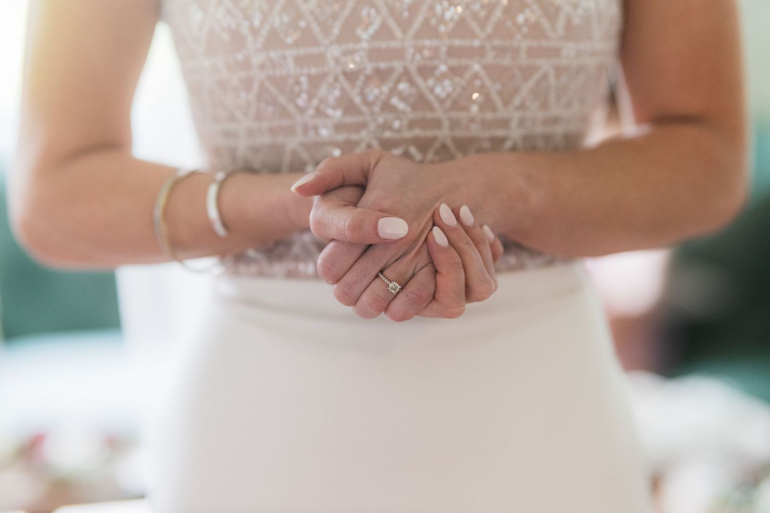 Closeup of hands wearing white dress showing delicate jewelry and gentle clasping.  at shady elms farm pittsburgh pa photography and video