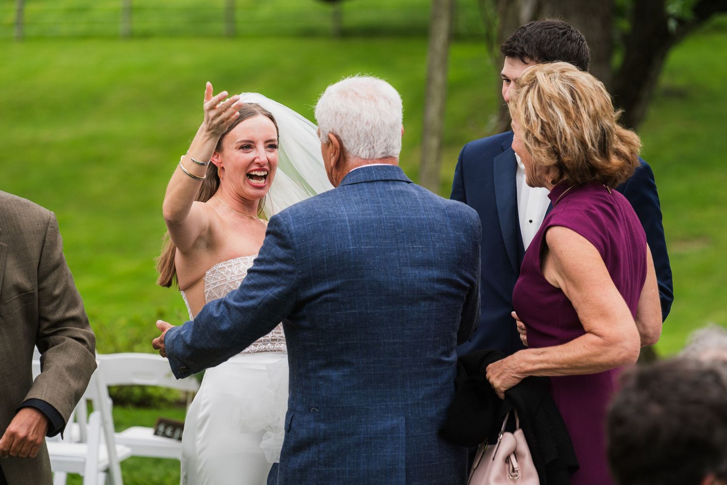 Wedding guests share joyful moments during an outdoor ceremony.  at shady elms farm pittsburgh pa photography and video