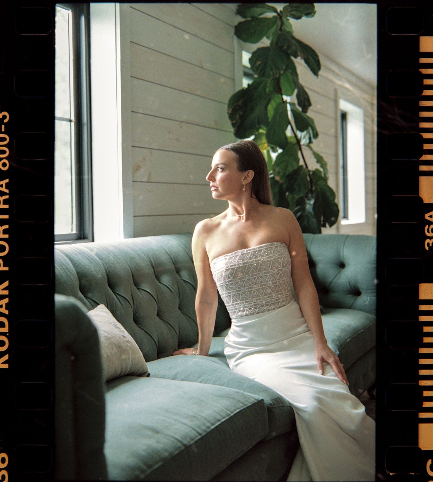 Wedding bride near window on a couch at shady elm farms pittsburgh pa photography and video by EternalLensMedia.com shot on film 35mm.