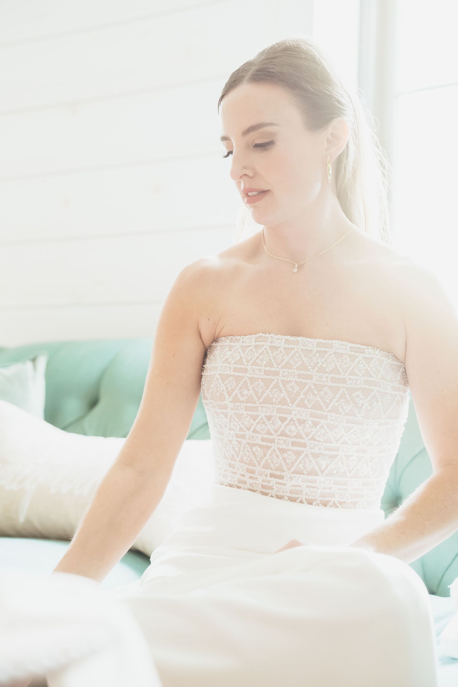 Ethereal bridal portrait with soft natural light highlighting delicate lace details of a wedding dress.