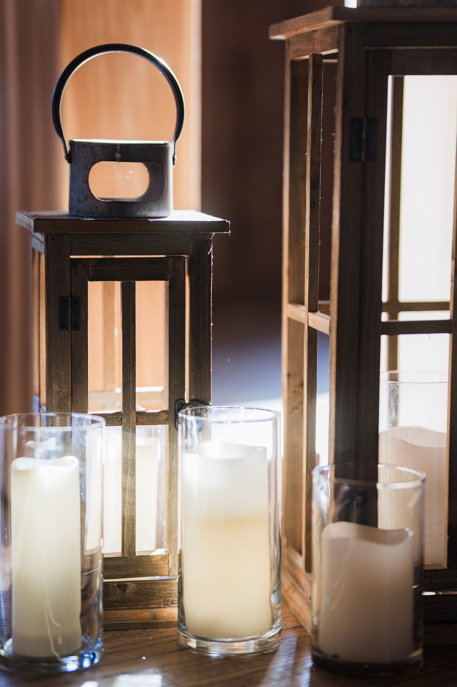 Black lanterns with glowing white pillar candles creating romantic wedding decor.